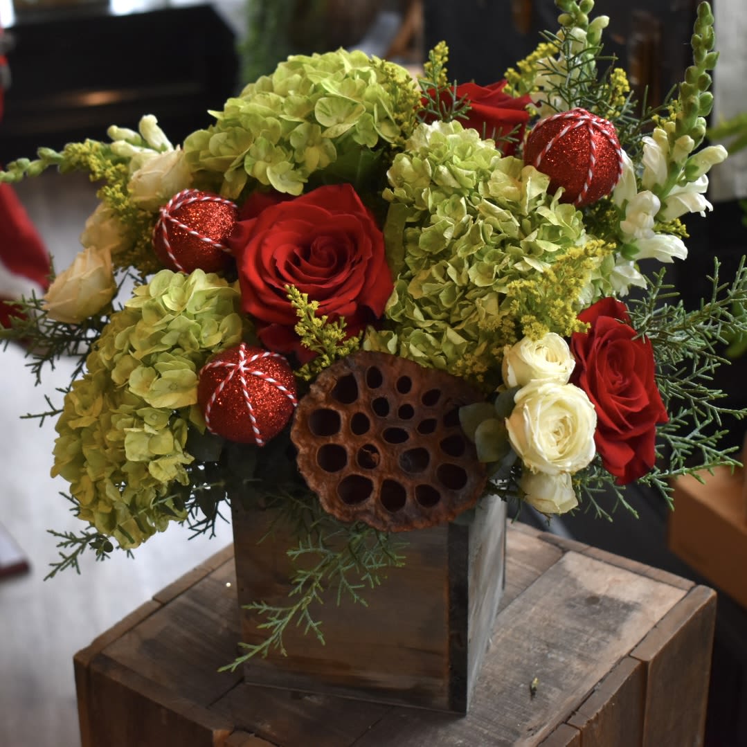 Crimson and Cypress - Rich red roses layered with winter greens and soft hydrangea, finished with festive detail. Timeless, refined, and unmistakably seasonal.