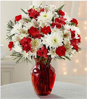 Joy to the World Holiday Bouquet - Picked fresh from the farm to help you celebrate the holiday season in style, the Joy to the World Holiday Bouquet, blooms with yuletide cheer and a festive grace your special recipient will love. Hand gathered at select floral farms and bringing together bright reds and crisp whites amongst lush winter greens, this stunning Christmas bouquet has been picked fresh for you to create a heartfelt holiday gift that will send your warmest season's greetings to your favorite friends and family. Bouquet includes: red Peruvian Lilies, red mini carnations, white chrysanthemums, white Peruvian Lilies, and lush holiday greens accented with a red present pick. Available with a classic red glass vase. GOOD bouquet is approximately 16"H X 12"W  Your purchase includes a complimentary personalized gift message.