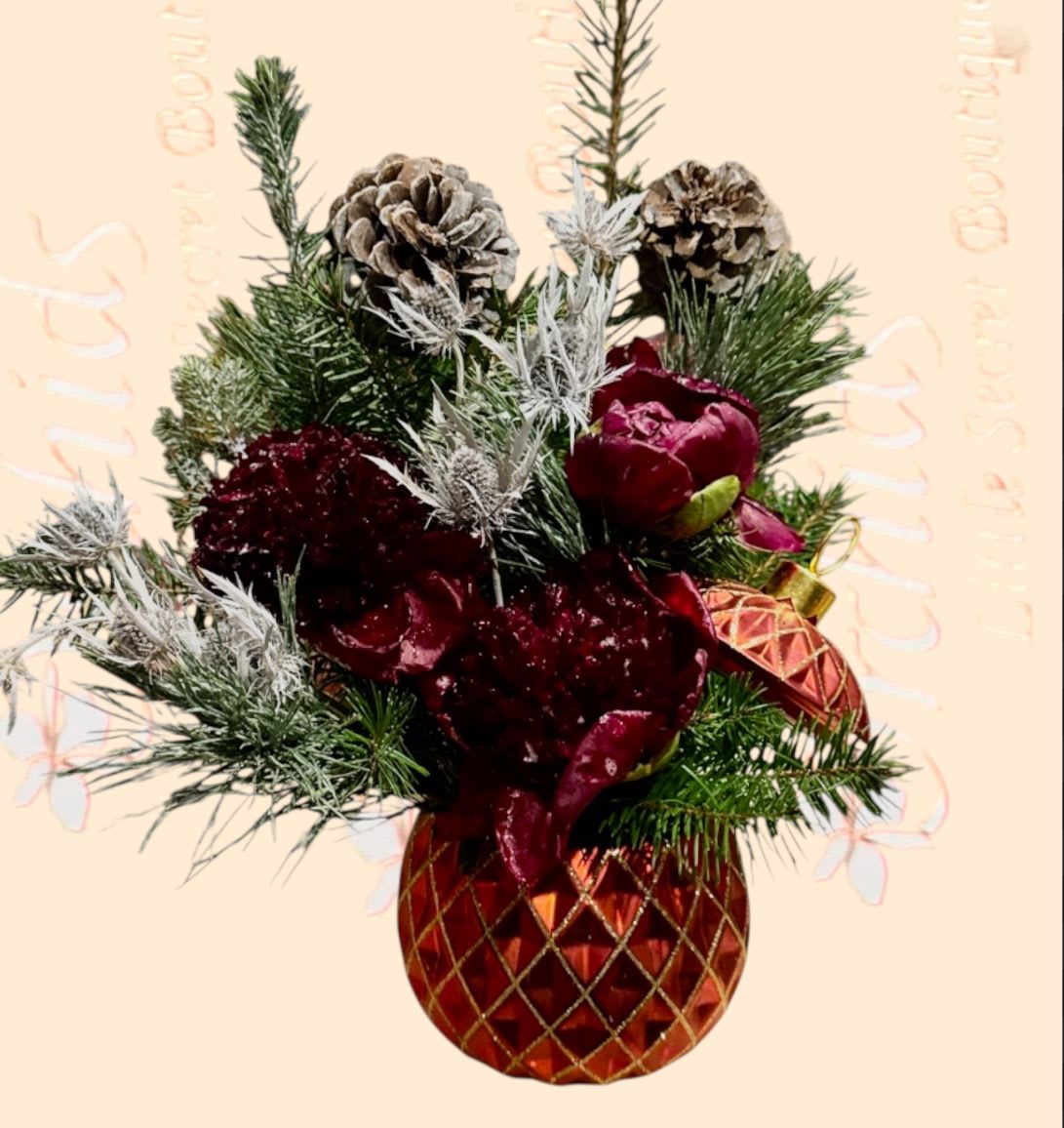 Red Peonies Pinecones Ornament Arrangement - Arrangement Measures approximately 15"H Offer a friend or family member a radiant ornamental sphere, featuring luxurious red peonies, winter pinecones, and celebratory foliage, expertly arranged in a modern, elegant red decorative vase. Include a warm holiday message with this seasonal arrangement, an ideal festive gift to illuminate a home and enhance holiday festivities.
