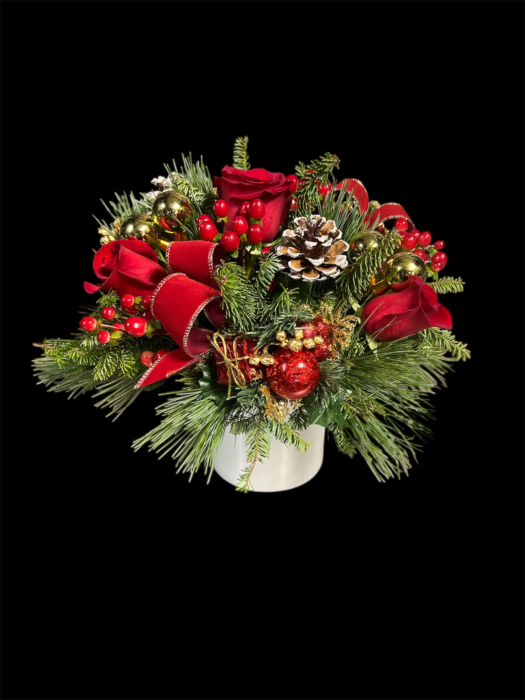 Crimson Christmas  - Bursting with festive charm, enjoy a vibrant mix of red roses, balsam, pine, and cheerful Christmas decorations.