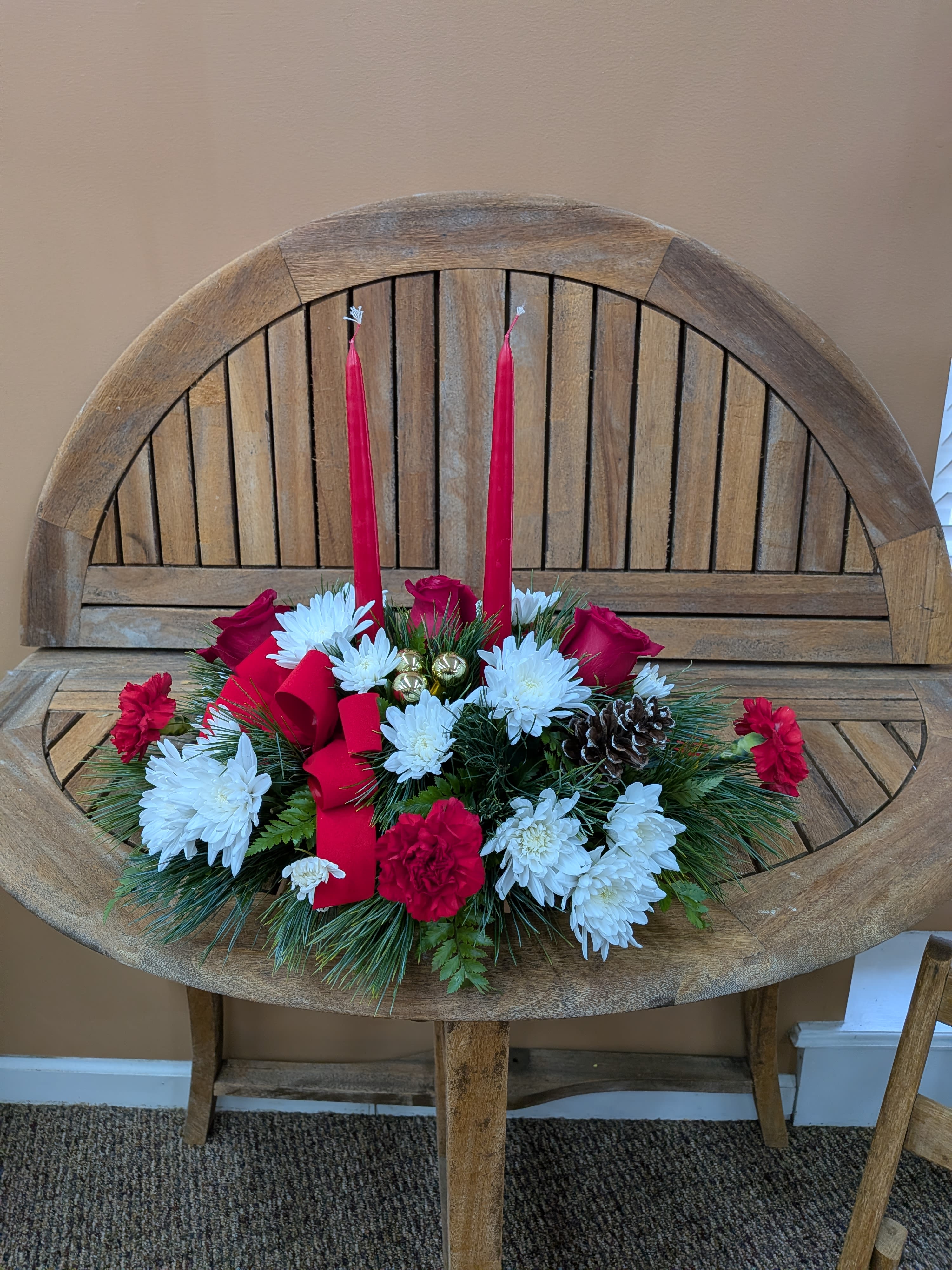 Festive Holiday Centerpiece  - Centerpiece with red candle, red ribbons, pinecones, red roses, red carnations and white poms.