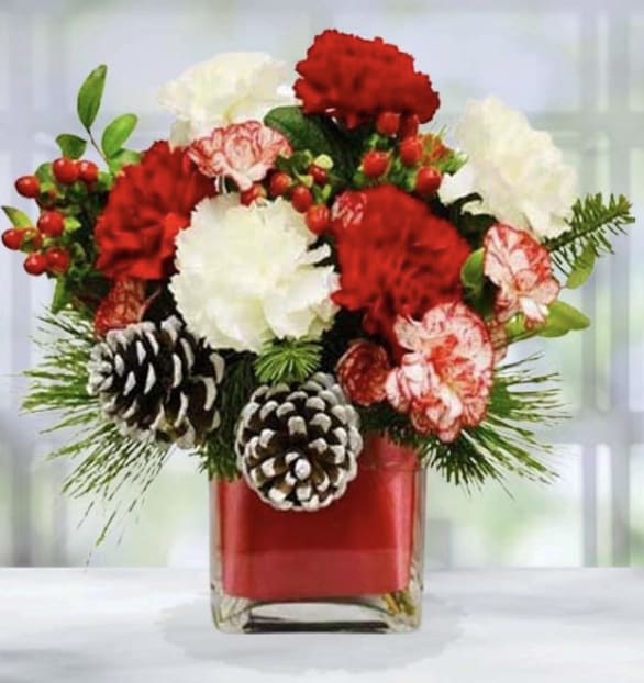 Season's Greetings Cube -  Celebrate the holidays with our Seasons Greetings Bouquet! This joyous bouquet features festive holiday embellishments and red hypericum berries that accent a beautiful assortment of red and white carnations. It is sure to bring holiday cheer to your lucky recipient. 