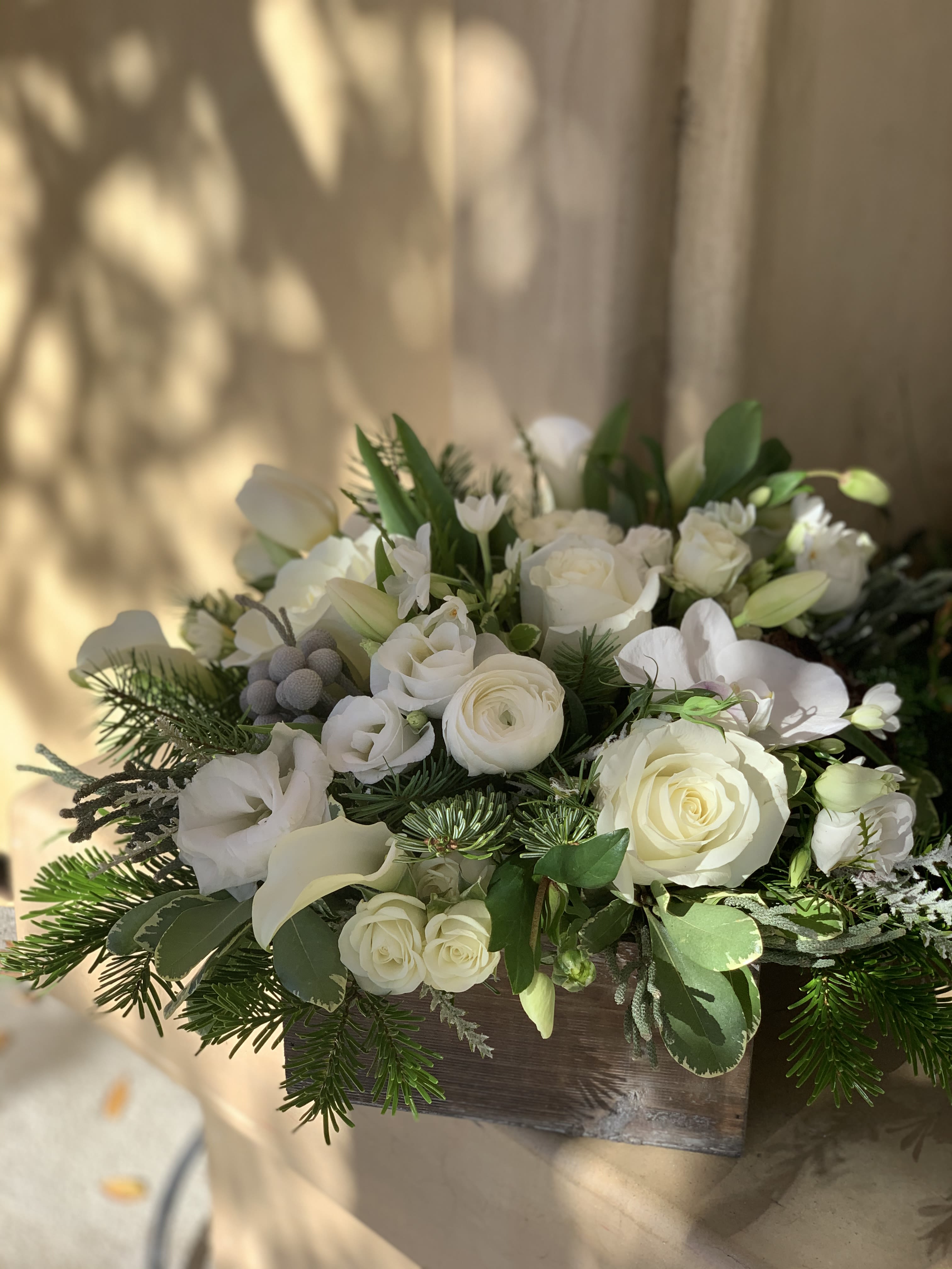 Snow Capped Trees - Classic take on whites and greens, clean with wintery touches , evergreens, and a rich blend of roses, tulips, lisianthus, all in a rustic keepsake box. 