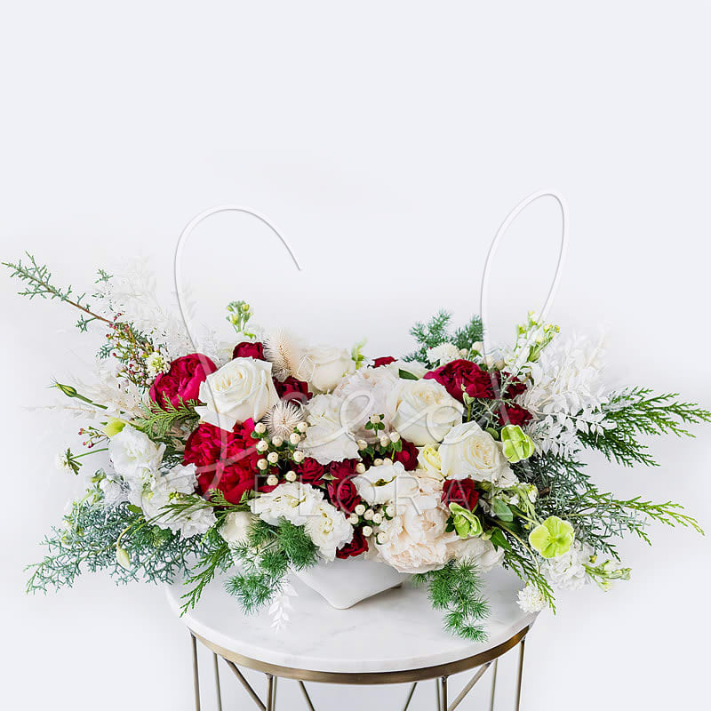 Home for the Holidays - Celebrate the season with our Home for the Holidays arrangement, a lush blend of premium fresh and dried florals in classic holiday hues of white, red, and green. Artfully arranged in our elegant Talia Bowl, this centerpiece brings warmth, elegance, and festive charm to any space.  Perfect For: Holiday tables, entryways, or as a thoughtful seasonal gift