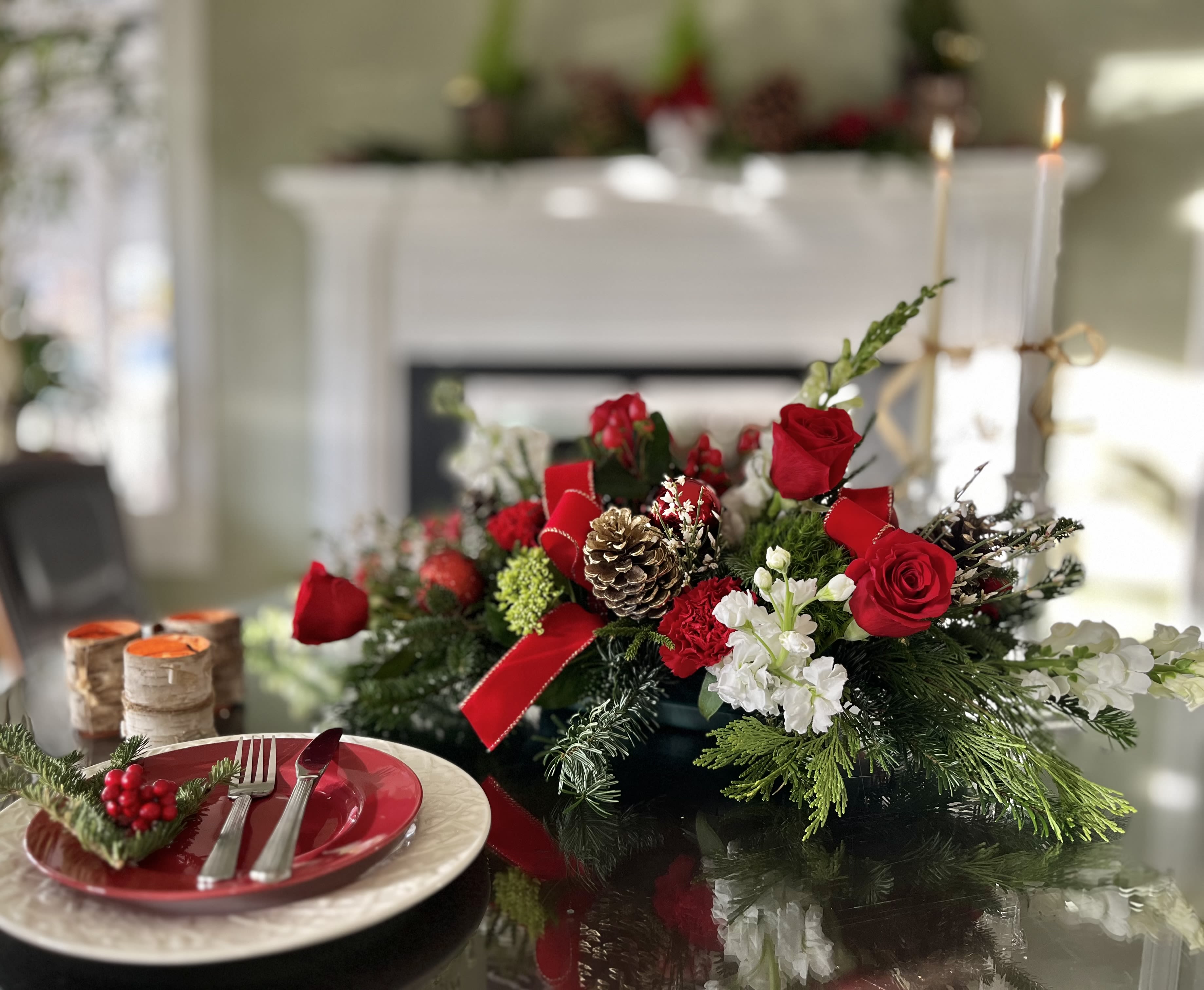 Holiday Centerpiece - Bring holiday magic to life with this beautiful centerpiece! Red and white flowers are arranged perfectly between the  winter greens that make the room smell cheery. Pineones, ribbon, and ornamnets are added for a fun festive feeling! We can do custom centerpieces as well, just give us a call. Centerpiece is for sale* decor is for scenery purpose only.