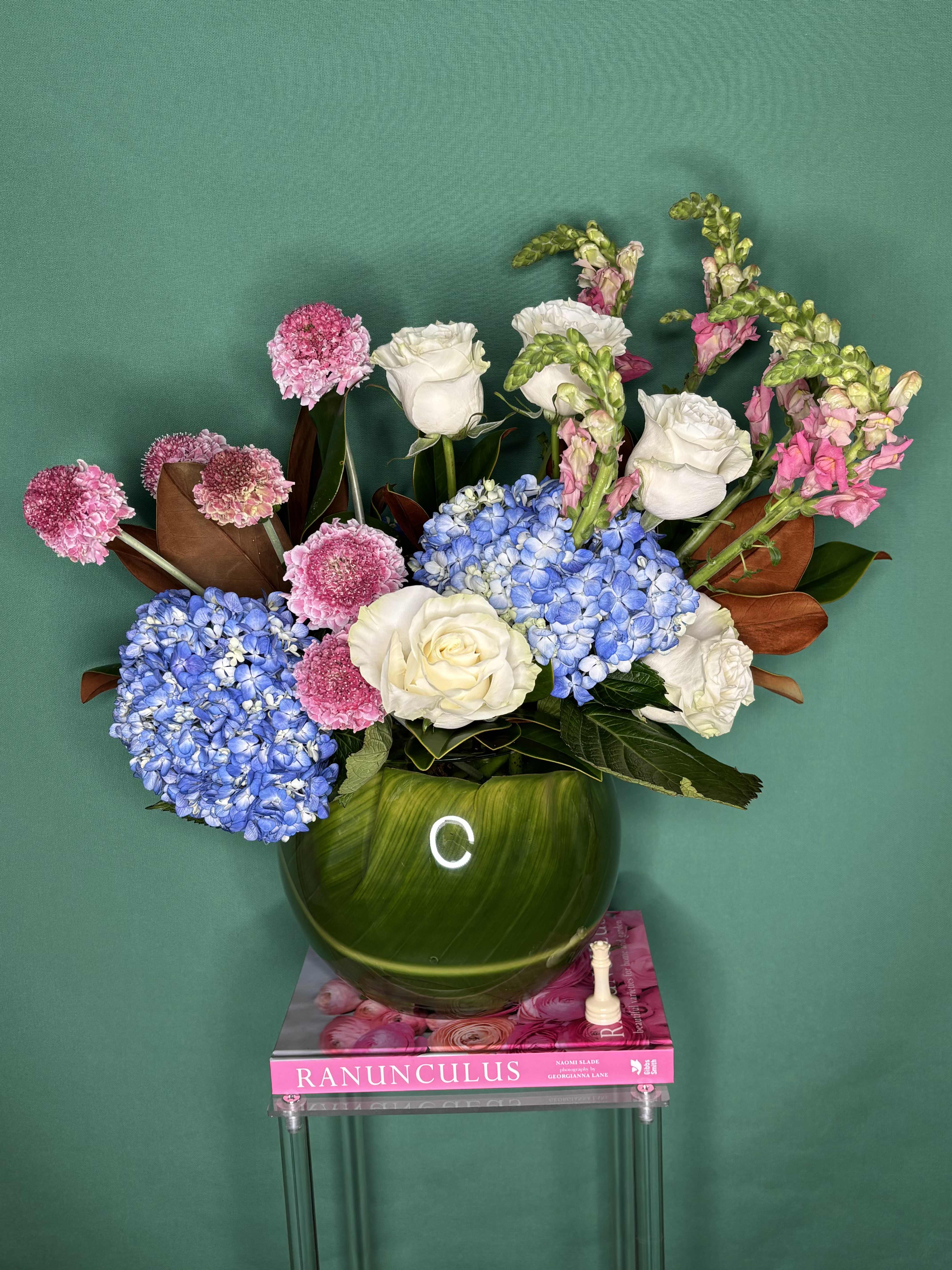 Havana. - A lovely and charming combination of blue hydrangeas, white roses, magnolia scabiosa leaves, and snapdragons. What could go wrong? Surprise her!  