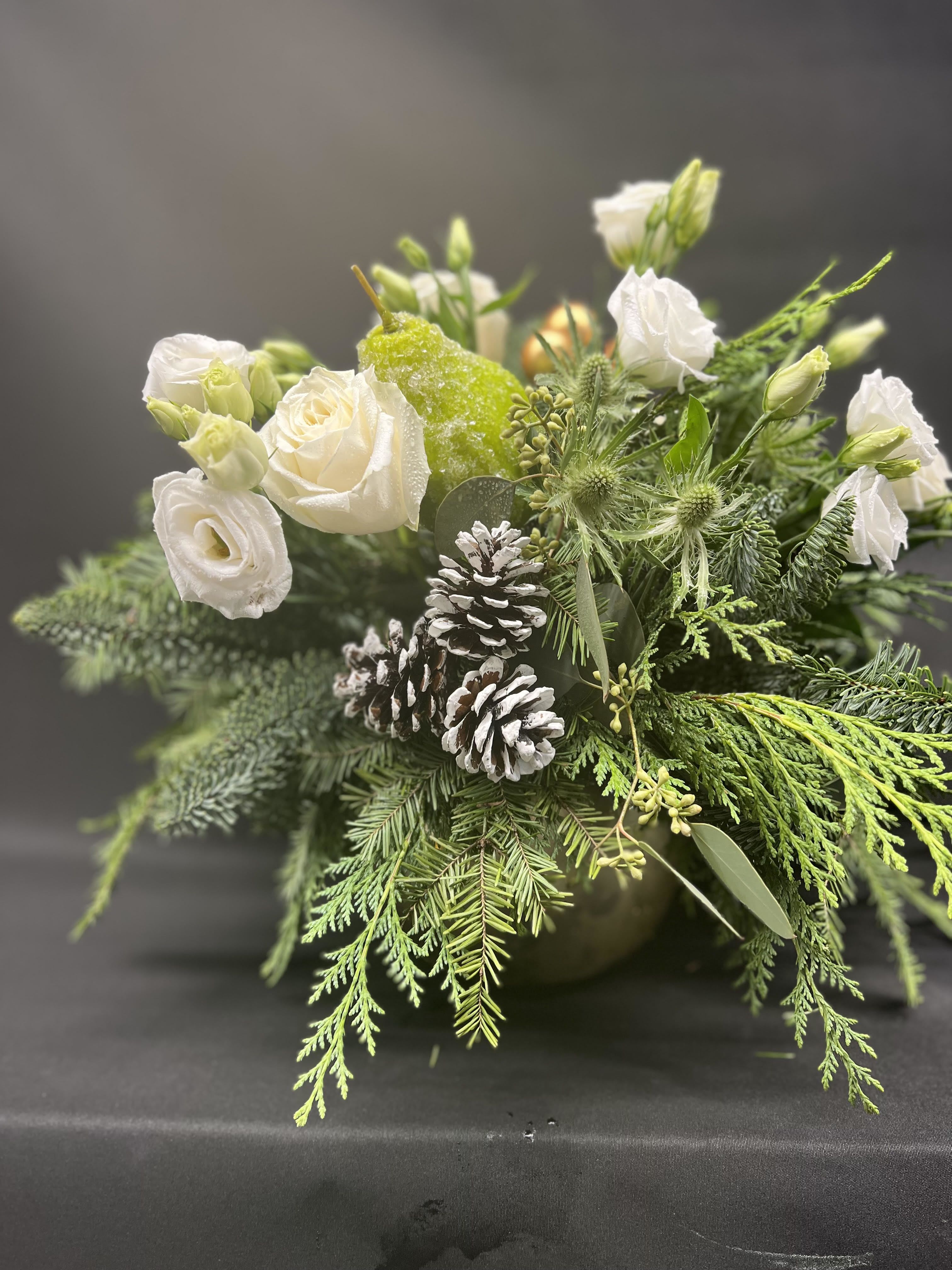 Silent Night  - A stunning classic white and seasonal greens arrangement , a bounty of white blooms and sugared fruit. Displayed in a shiny gold ceramic container. 