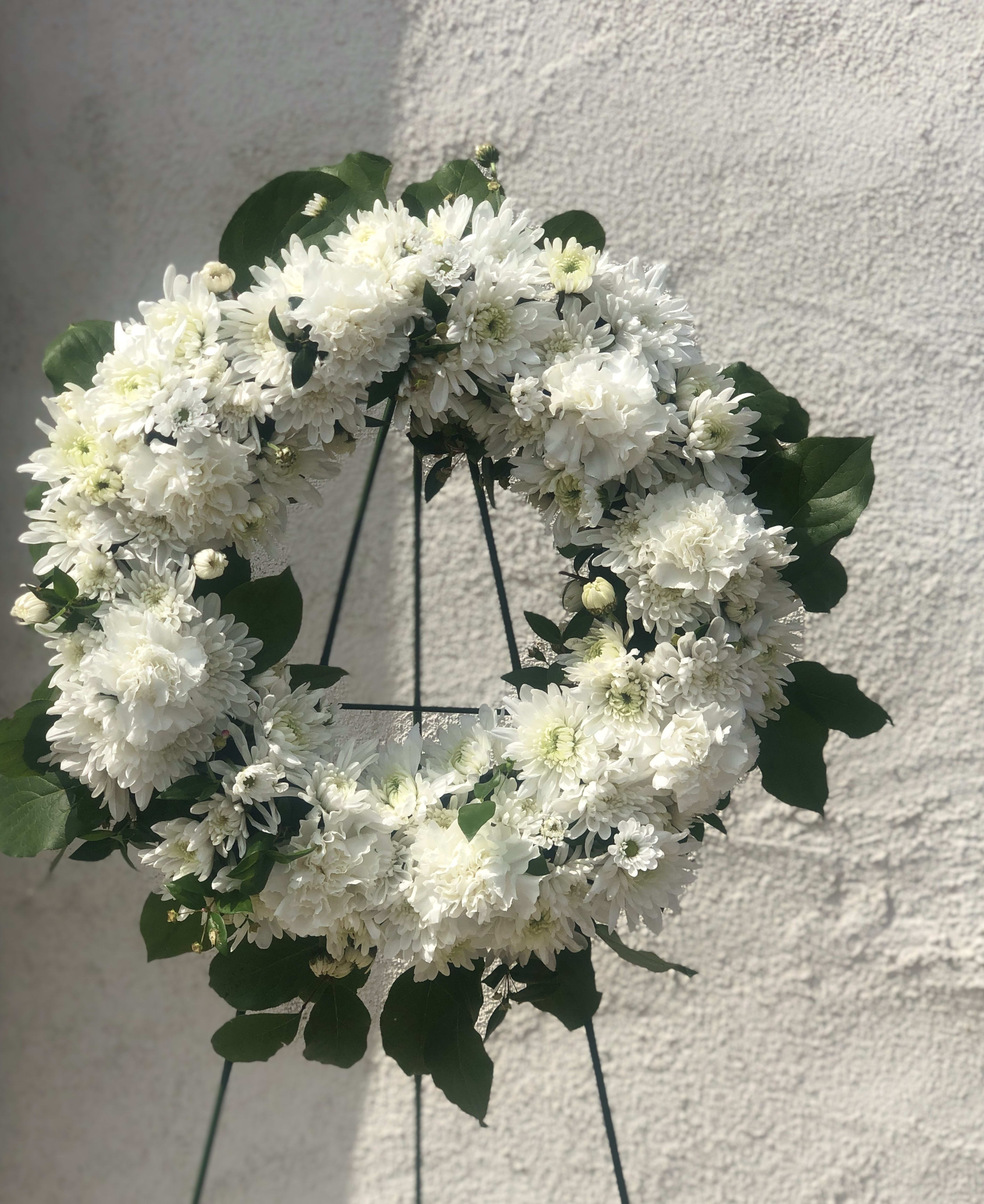With Love &amp; Hugs Open Wreath 15" Standing Spray - Express your deepest sympathies to a recipient that lost a loved one With Love &amp; Hugs Open Wreath Standing Spray filled with white blooms !  Measuring approximately 15 inches in diameter, and displayed on a wire easel.