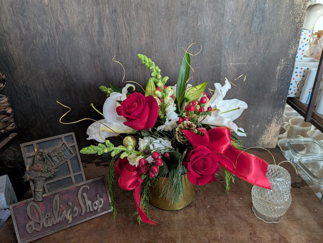 Christmas vase Centerpiece - Cedar, pine, Ting Ting, Pinecones, Ornament, Bows accent the beautiful lilies, hydrangeas, red roses, berries, in a cylinder with gold ribbon wrap.
