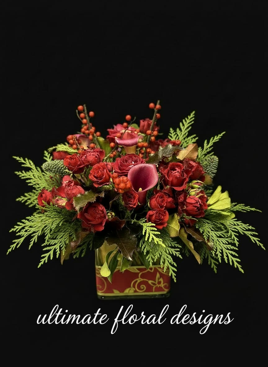 Crimson Garden Elegance - A luxurious floral arrangement featuring premium garden roses, seasonal berries, and lush evergreens, artfully designed in a decorative keepsake vase. Crimson Garden Elegance captures rich texture and timeless sophistication, blending classic florals with natural greenery for a refined, festive statement.  Perfect as a striking centerpiece or an elevated gift, this arrangement brings warmth, depth, and couture floral artistry to any setting.  Perfect for: Holiday décor • Luxury gifting • Corporate arrangements • Dining tables • Seasonal celebrations