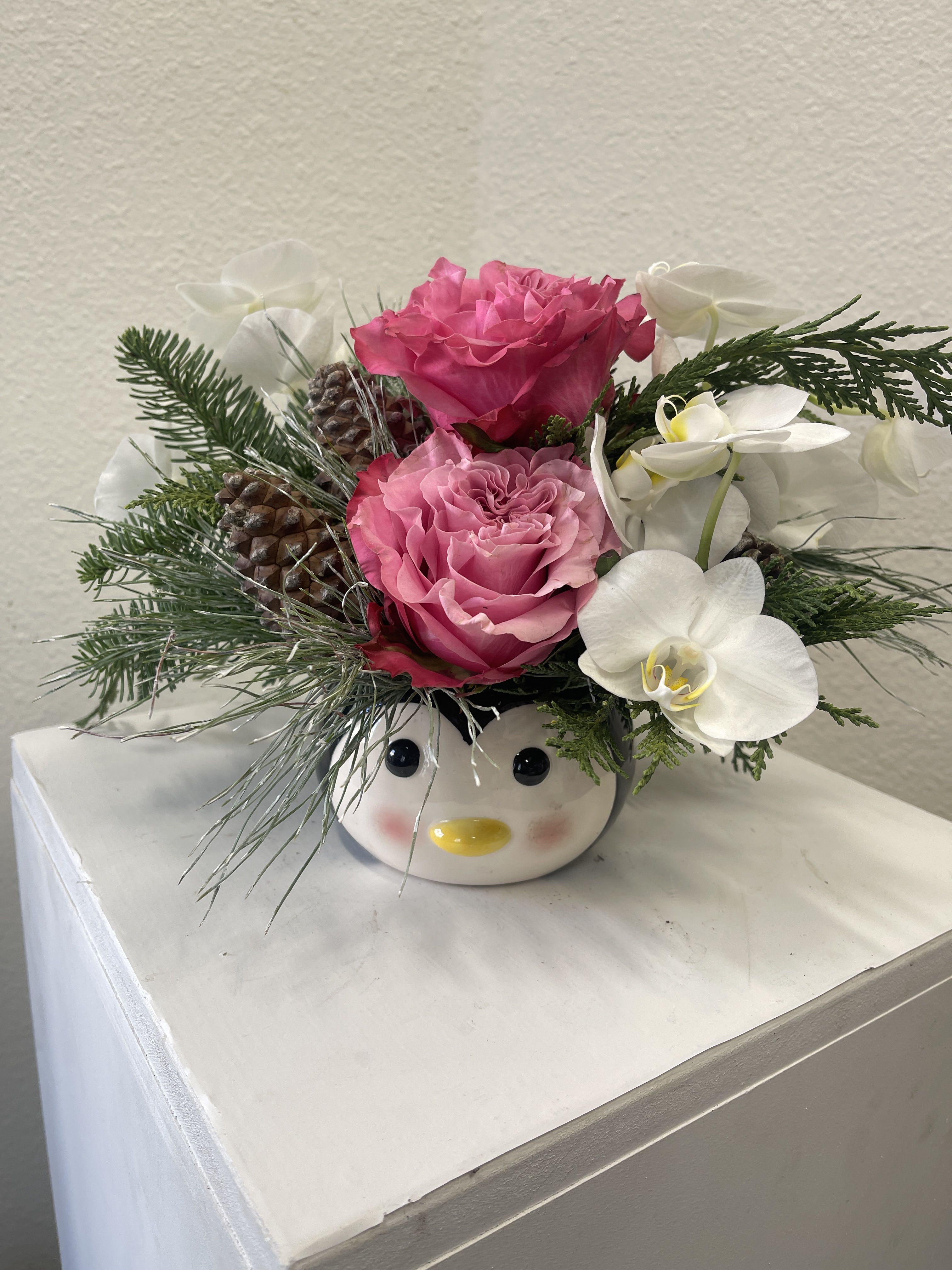 Blushing Penguin - Keepsake Penguin ceramic with winter’s finest flowers and evergreens.