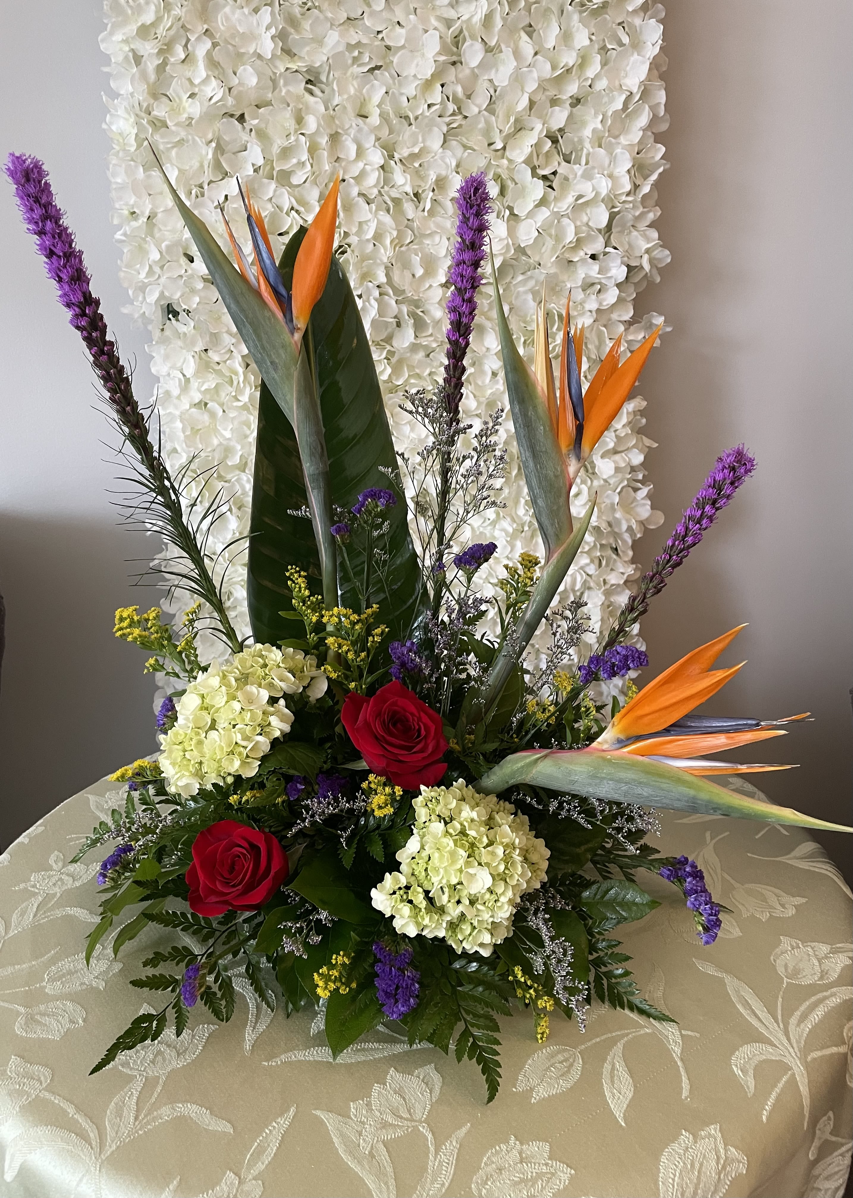 A Rare Bird in Paradise - This Arrangement includes Purple Liatris, Bird of Paradise, Red Roses, Green Hydrangea, Yellow Solidago, Purple Statice and Caspia with Assorted Greenery.
