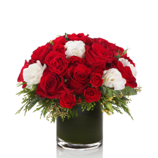 PEPPERMINT  - A festive mic of red $ white rose &amp; white lisianthus atop a bed of Christmas greenery arranged artfully in a chic glass vase  