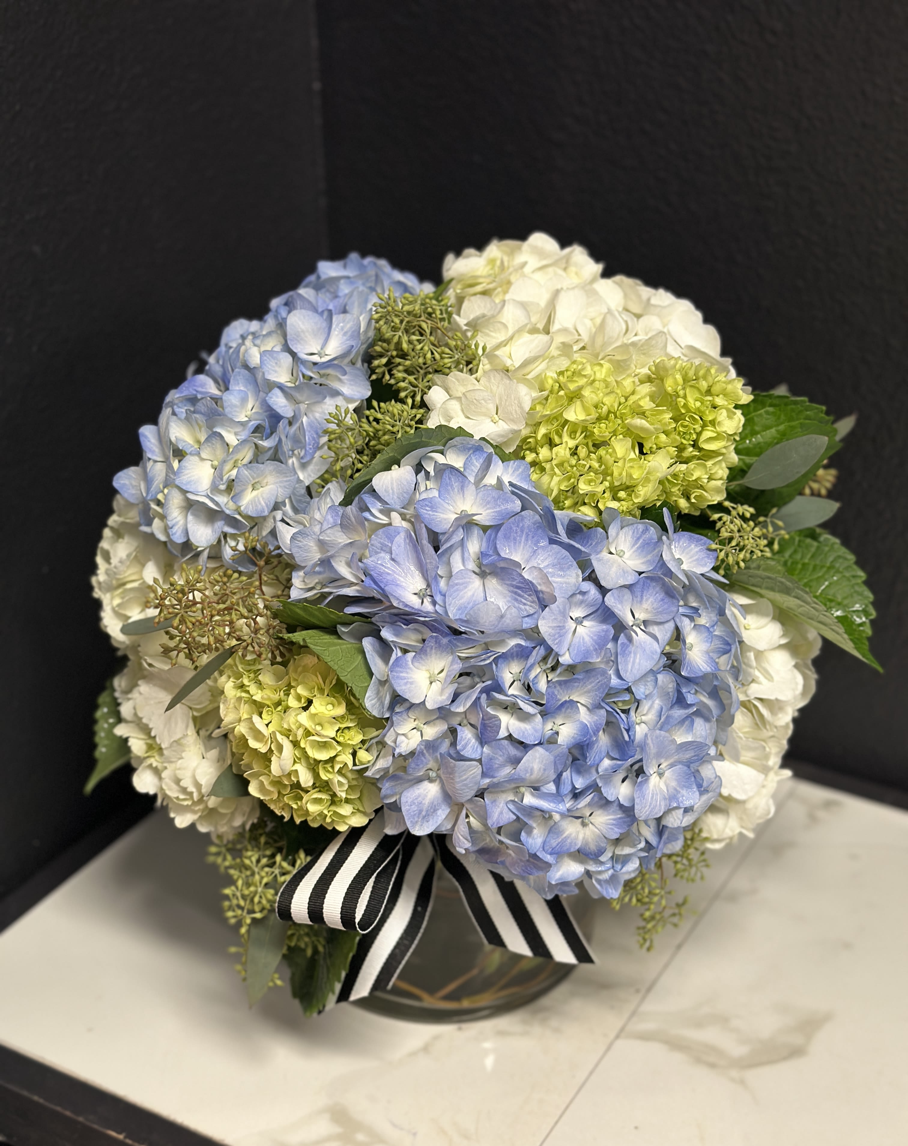 Blue &amp; Cream Hydrangea En Masse  - An elegant option for any occasion. Mixed hydrangea's en masse delivered in a clear glass vase.  Standard size is approximately 15" x 15" 