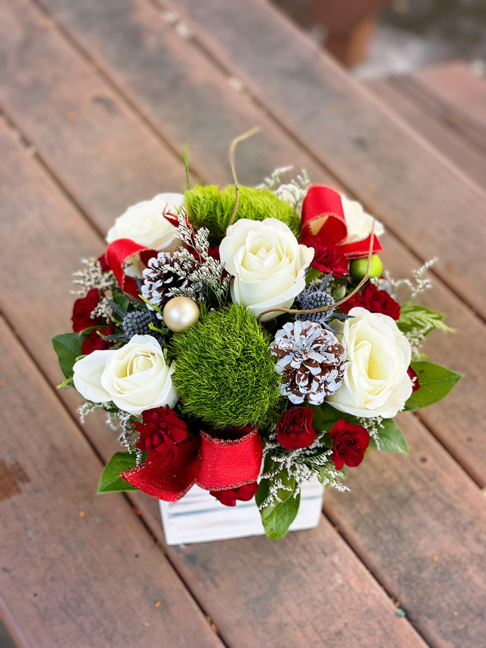 Winter Fresh - - 6 White Roses - 5 Red Mini Carnations - 2 Green Tricks - Christmas Greens - Pinecones - Ornaments - Ribbons - 5 inches Wooden Box