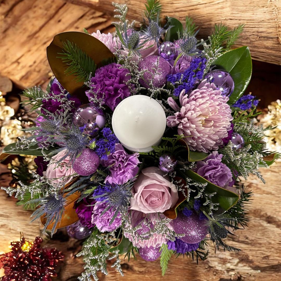 Grand Center piece in purple with candle 23 -  Our photos represent the overall style and theme of each arrangement. Some vases or flowers may be one-of-a-kind and cannot be exactly replicated. Due to weather, seasonality, and market conditions, substitutions may occur. If needed, we will maintain the design’s style, theme, and color palette and only substitute items of equal or higher value.  If certain design elements are important to you, please mention them in the florist instructions at checkout or contact us to confirm availability.  Flower Care &amp; Guarantee  We guarantee flower freshness for 24 hours after they leave our shop.  Because flowers are natural, some blooms may open more fully than others.  Care Tips:  Cut flowers: Trim stems by 1 inch every 2–3 days and place in fresh water.  Arrangements in foam: Add about 1 cup of water to the foam every couple of days.  After 24 hours, proper care becomes the customer’s responsibility.  Thank you for choosing our shop!