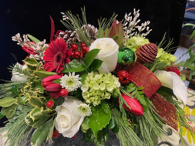 Regal Christmas Centerpiece - Traditional elegance for your holiday table.  Pine cones, winter greens and a sparkle here or there with premium rich red roses and Mojito hydrangea work well together in this lovely centerpiece.  Approximately 16" wide.
