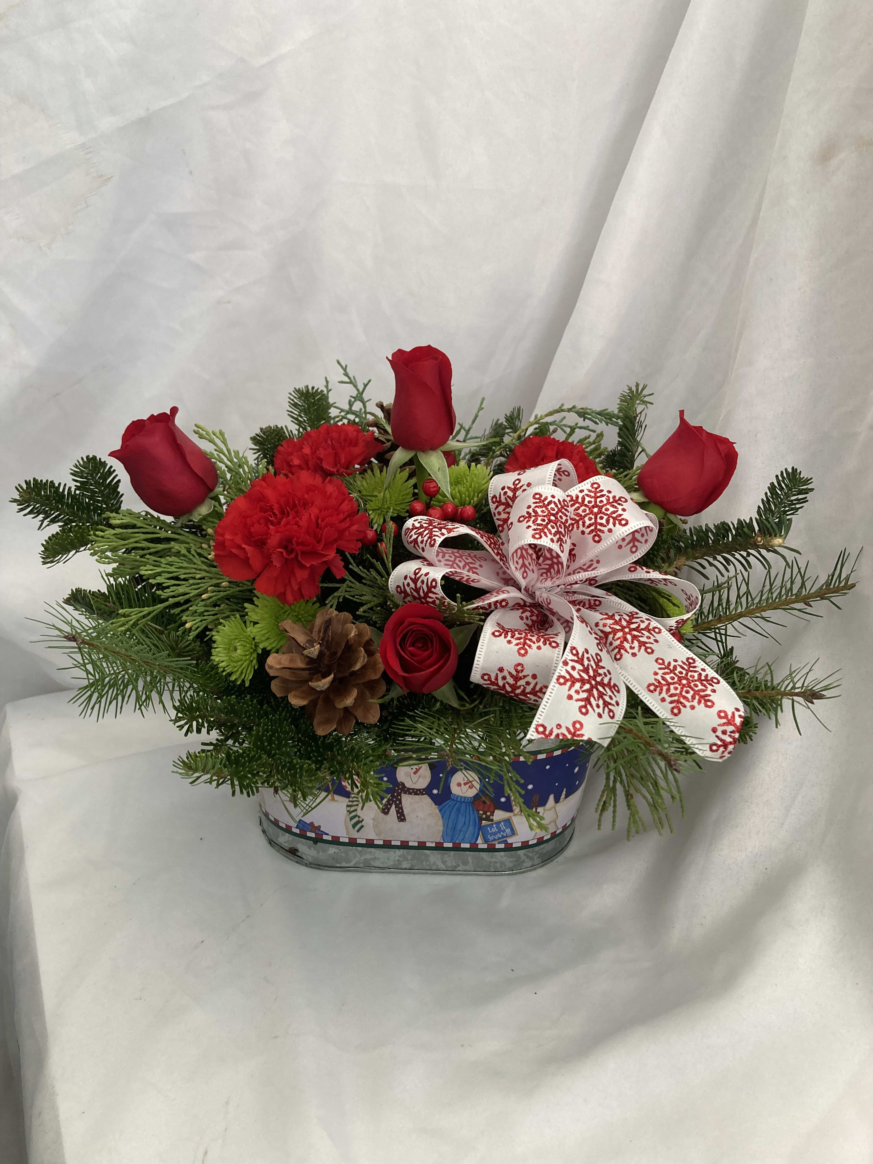 Simply Christmas  - A delicious blend of red roses and carnations with lush Christmas greens and cones topped off with a beautiful bow.