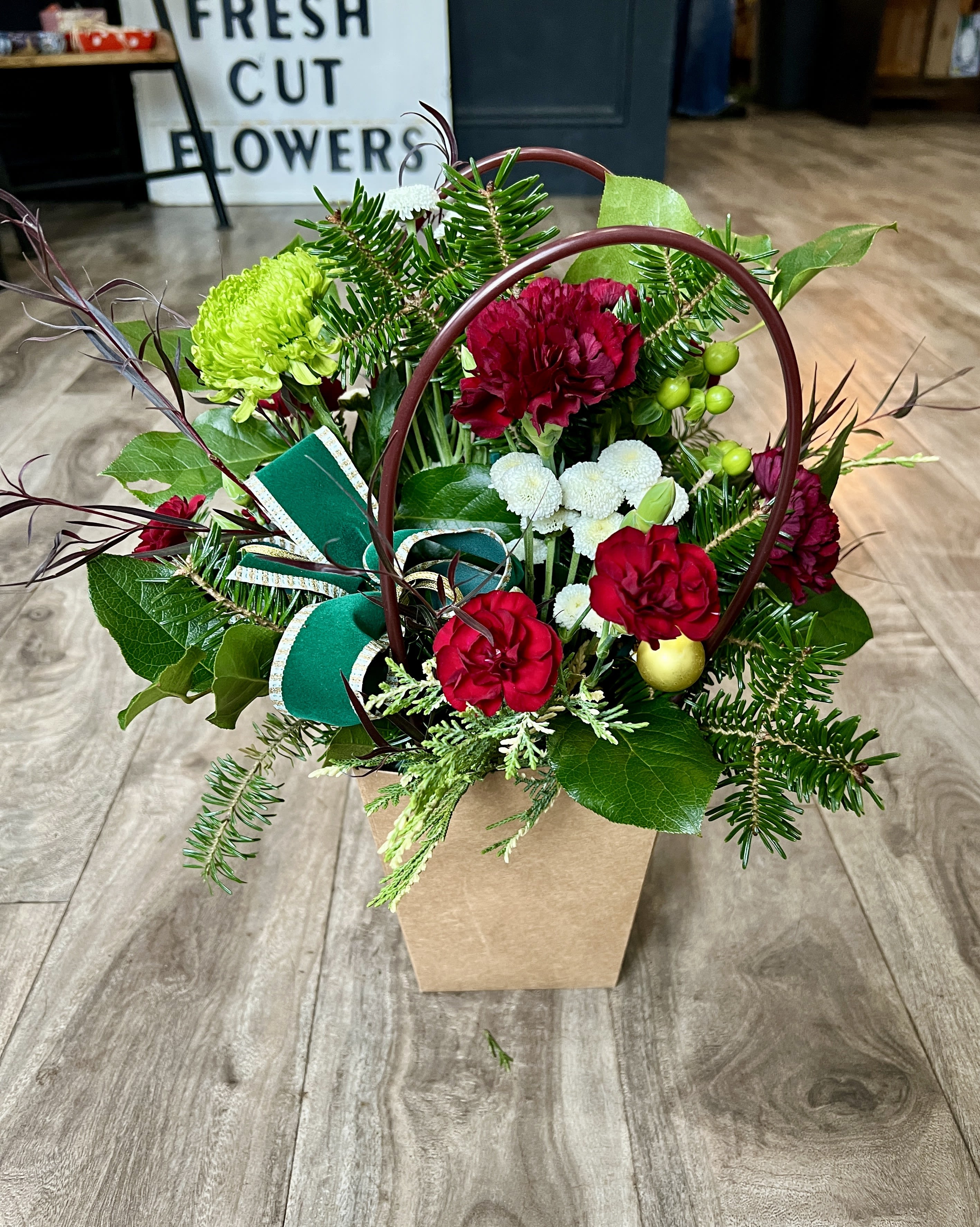 Holiday Cheer  - A festive arrangement in a brown bag container. 