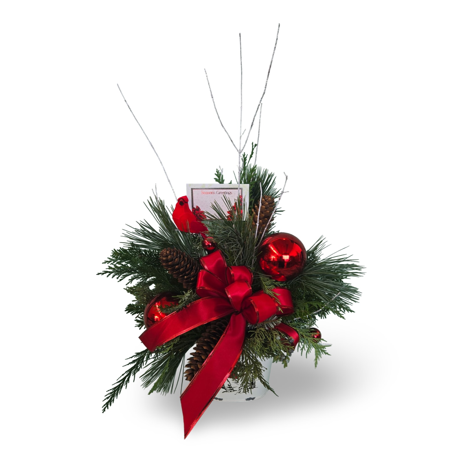 Countryside Christmas - Every family has its own holiday traditions, and our charming arrangement could be one of yours! Beautifully arranged using fresh, crisp winter greens, pinecones, ornaments, red cardinal, white accent sticks and a charming red bow. This arrangement is sure to bring charm to any holiday gathering.