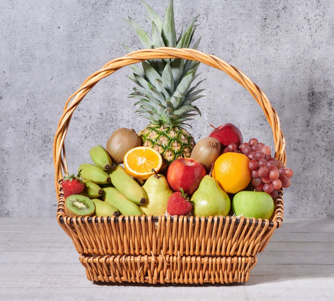 Fruit Basket - This Fruit basket is a delicious and beautiful fresh fruit selection. Artfully arranged, this fruit basket includes pineapple, bananas, mangos, kiwis, apples, oranges, pears, strawberries, and red grapes. Everything is packed with care into a classic wicker gift basket for presentation and display. This delicious gift is perfect for marking any occasion, whether it’s a graduation, anniversary, getting over an illness, or just because.
