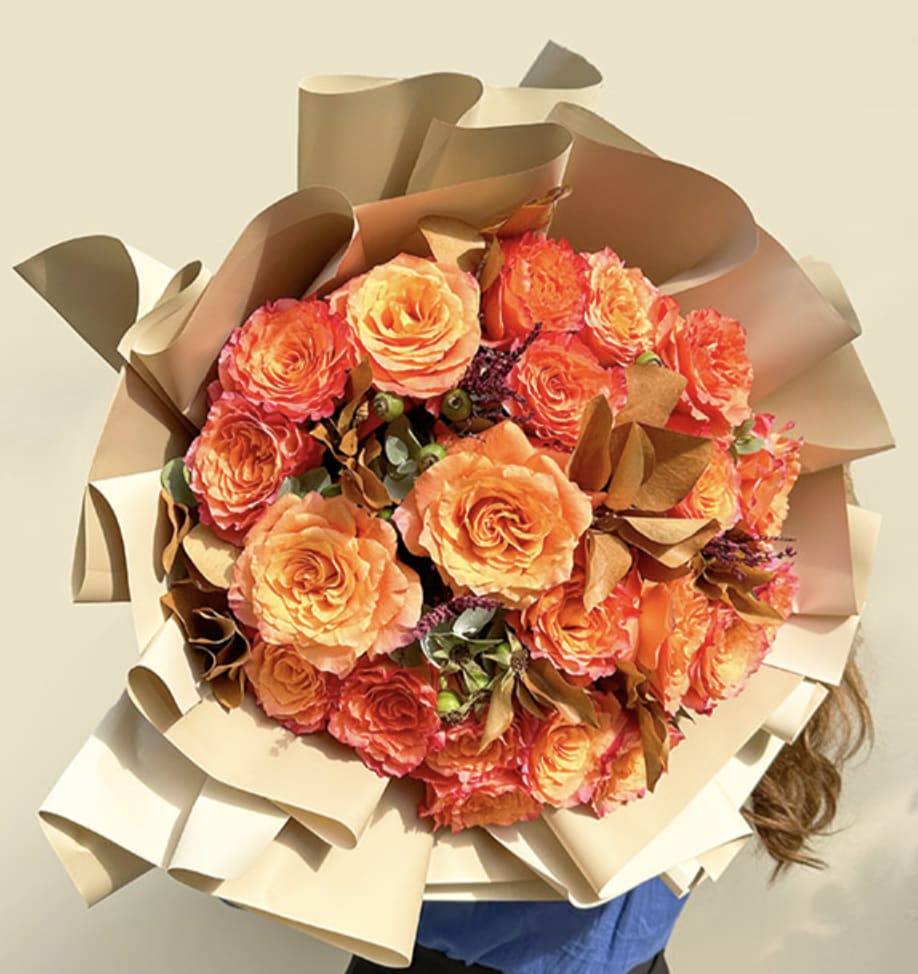 Miami Beach Golden Hour - A striking bouquet that glows with the warmth of the evening sun. Featuring vibrant orange roses kissed with hints of deep burgundy and accented by fresh greenery.