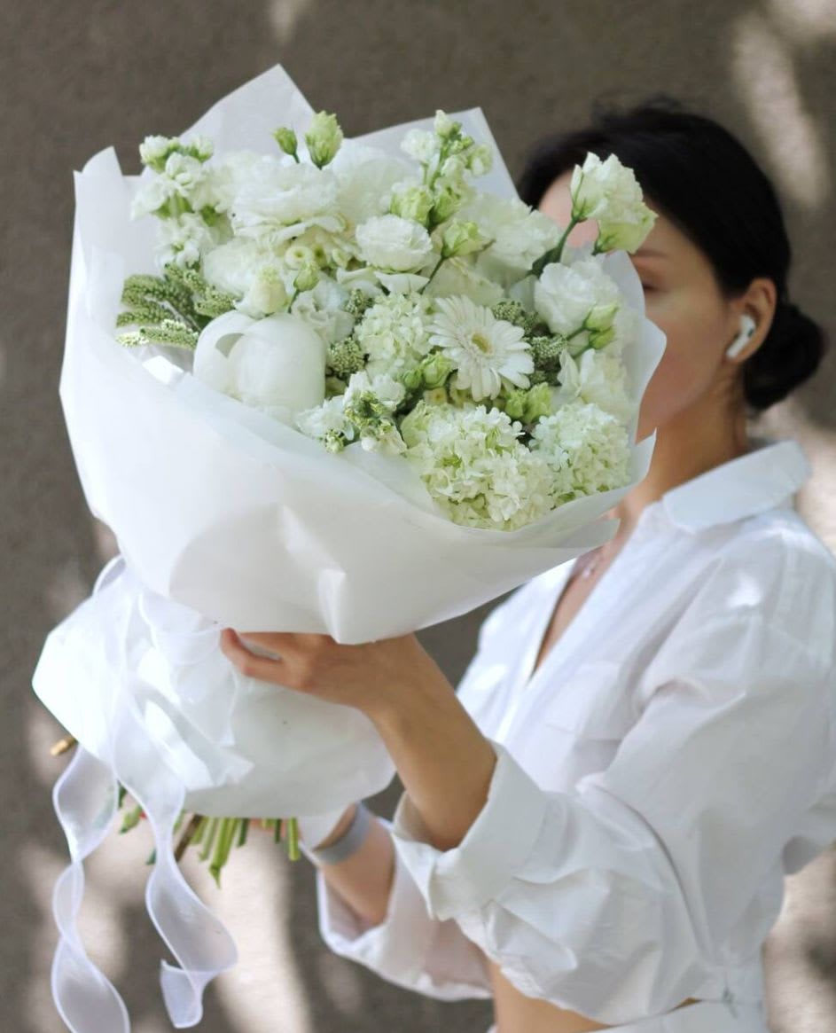 Angels' Bouquet - Beautiful lush bouquet of white flowers wrapped in white paper and ribbon.