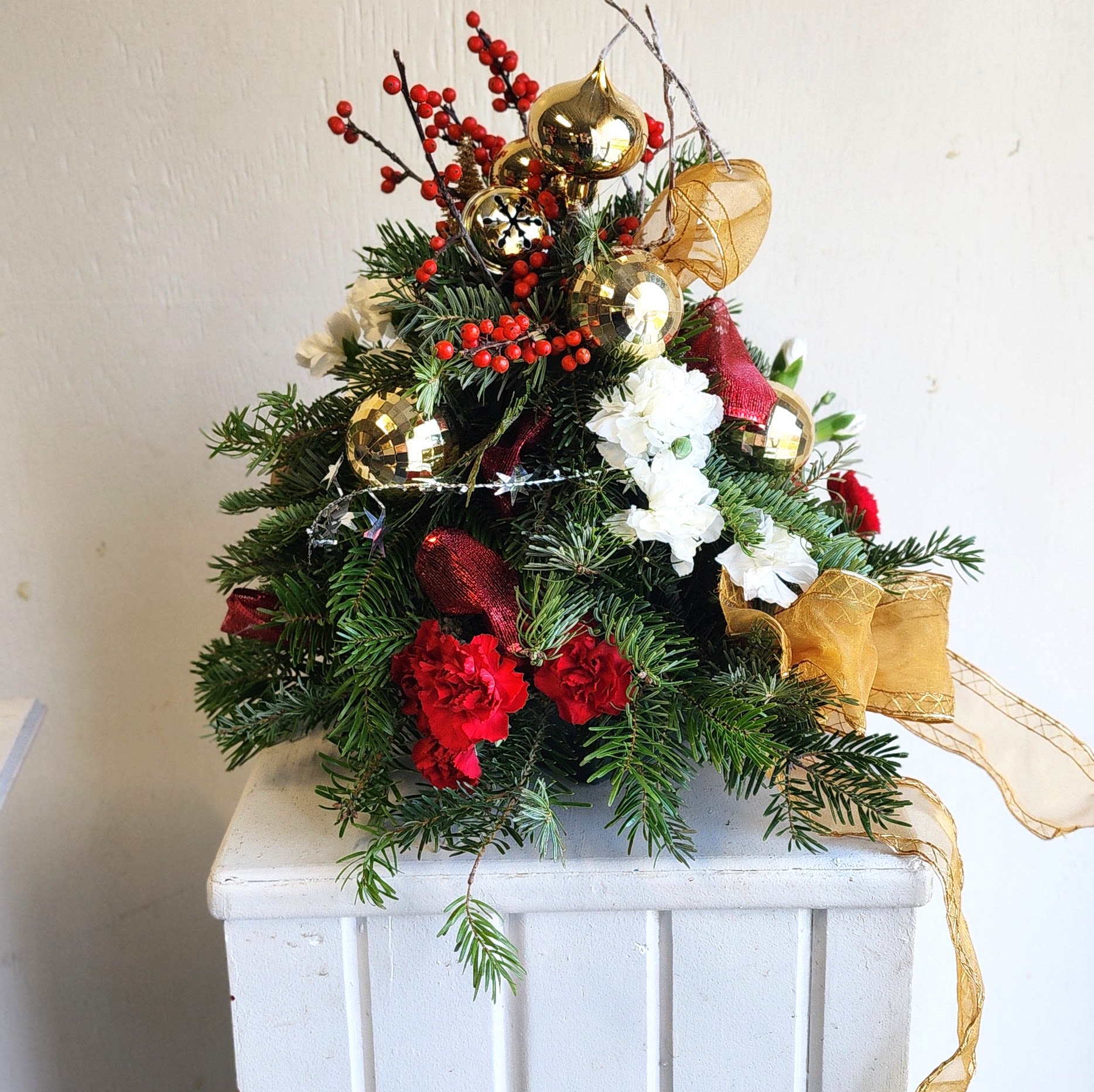 Mini Christmas Tree -  An 18-inch Christmas tree that we will create, decorate, and deliver for you. So fun, cute, and mini!  We are a custom design studio florist in a small town. Every bouquet we create is a one-of-a-kind creation, tailored to the season, availability of flowers, color choice, artistic interpretation, and the current materials available. The photos do not represent the exact flowers that will be delivered. They are intended to provide you with an idea of what we do, how we do it, and the variance that can be expected.A fresh mix of stems chosen for their color and character—ready to be shaped into a personal masterpiece. 