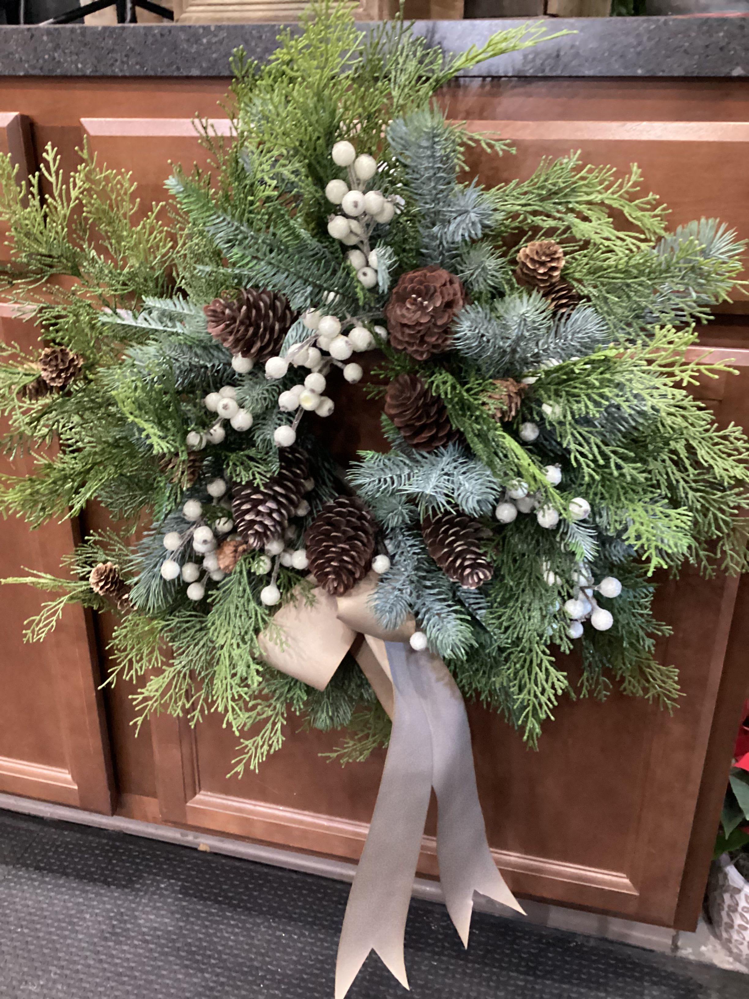 Permanent Cream Pinecone Wreath ON SALE - A holiday wreath with cream colored berries and ribbons, decorated with pinecones