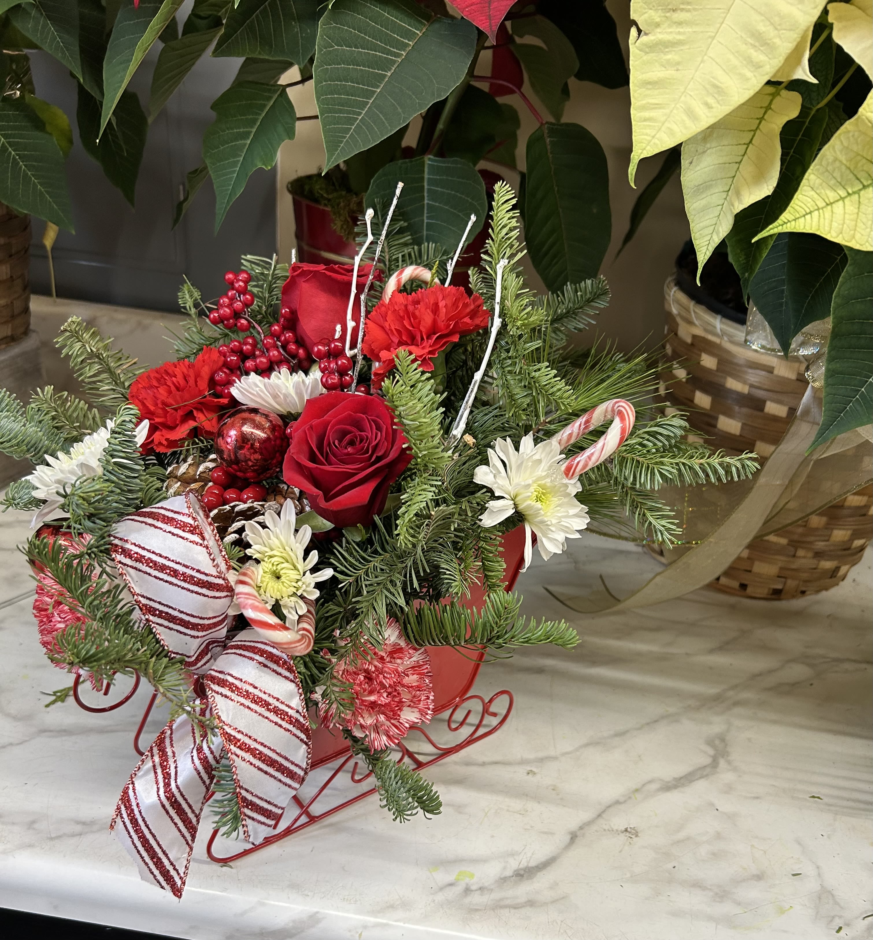 Chris Kringle sled - Red and white mixed flowers in a sled
