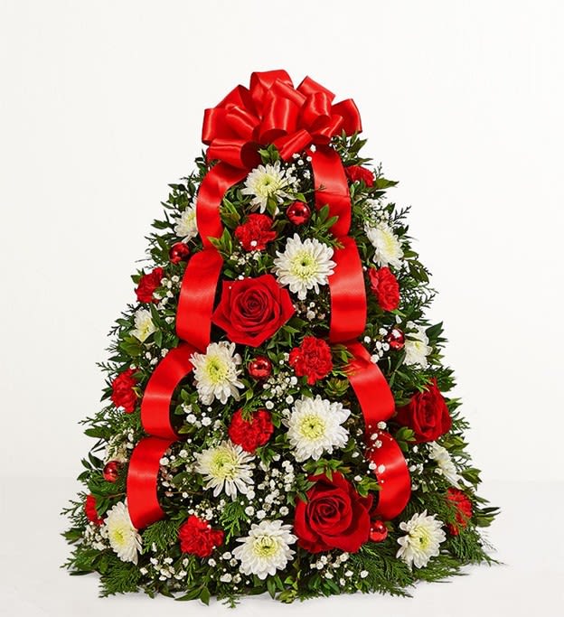 Holiday Boxwood Tree - •	Tree-shape boxwood arrangement with red roses and mini carnations and white cushion poms, accented with baby’s breath, assorted Christmas greenery, red ball ornaments, and a red bow topper