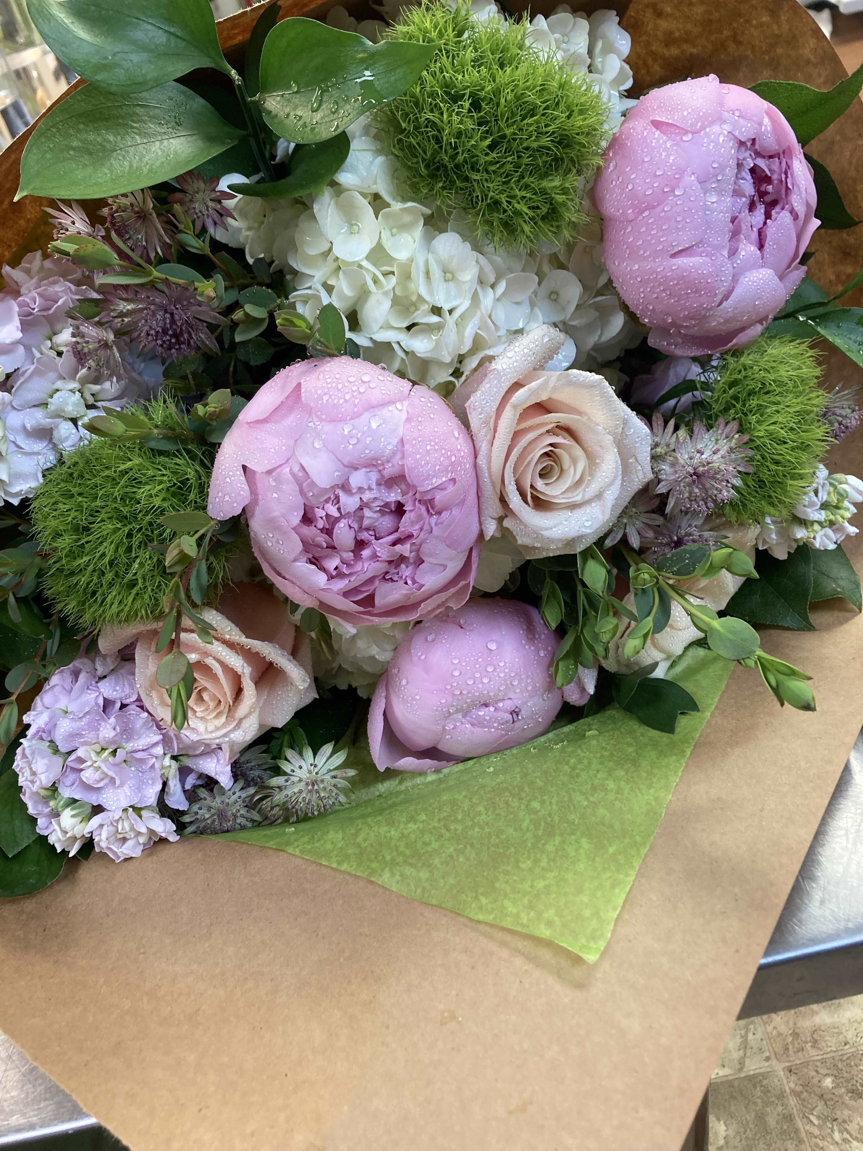 Loose wrap Bouquet: Romantic Collection - A seasonal Romantic collection of blossoms in loose wrap style - This bouquet does NOT come in a vase. Specific blooms vary upon freshest inventory.