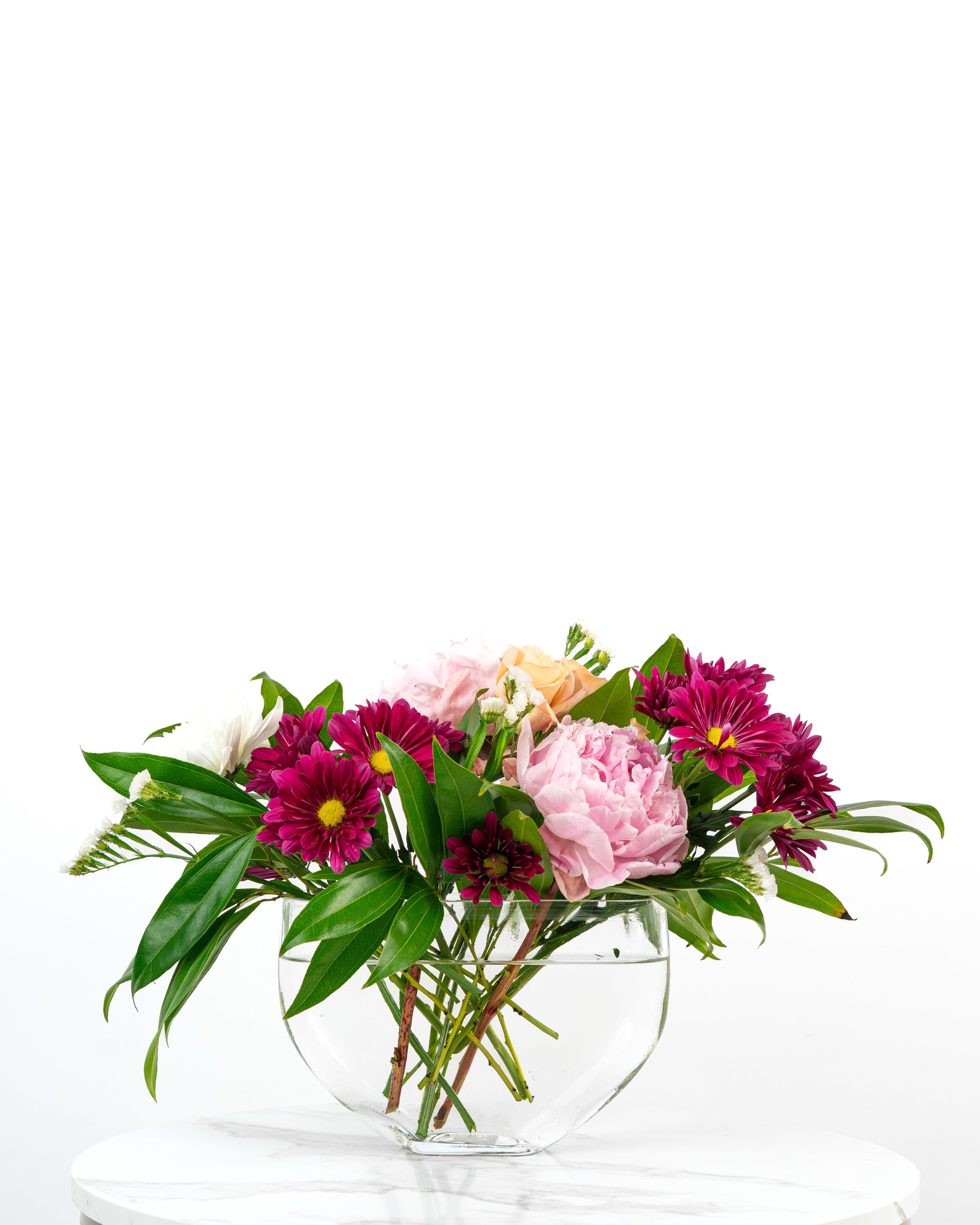 Collector's Birthday Surprise - Let our floral design team send birthday wishes with a color and style chosen based on our best premium blooms using a modern, glass moon vase. At Schultz Floral, each arrangement is one of a kind and styled just for your order. Because we always use the freshest blooms, your final arrangement may not look exactly as pictured due to seasonal availability. Rather, a Collector's Birthday Surprise is intended to celebrate creativity and artful color combinations. Happy Birthday!  This is a top seller in Valparaiso, Chesterton, and Aberdeen (Indiana).