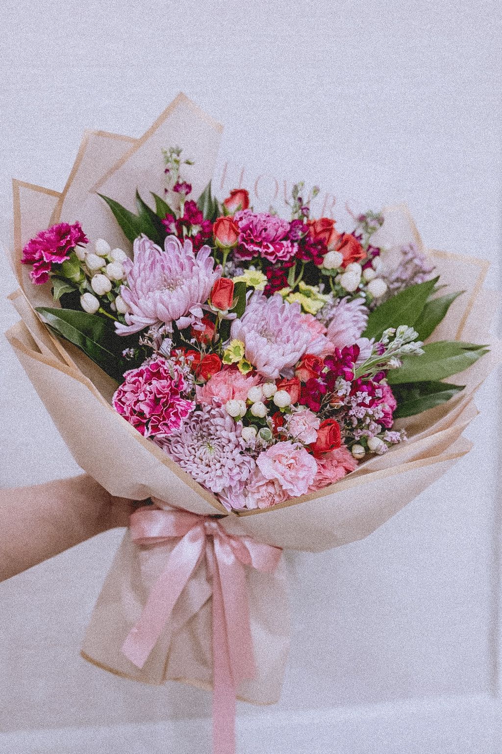 Garden Charm Bouquet Wrap - A thoughtfully designed bouquet featuring a harmonious mix of seasonal blooms in soft pinks, vibrant magentas, and delicate accents, wrapped in natural kraft paper and finished with a soft satin ribbon.  Perfect for birthdays, celebrations, thank you gifts, or simply to brighten someone’s day.  • Fresh, seasonal flowers • Handcrafted design • Wrapped in natural kraft paper • Same-day or next-day delivery available  Please note: Flower varieties may vary slightly based on seasonal availability, while maintaining the overall color palette and style.