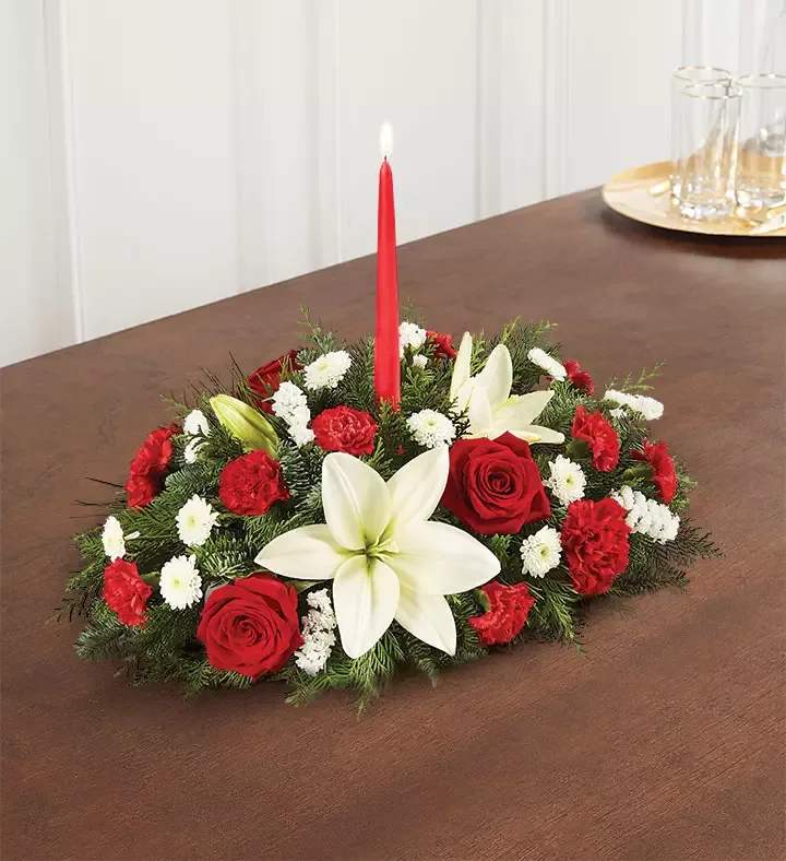 Traditional Christmas Centerpiece - Our classic table arrangement is an idyllic centerpiece for your Christmas celebration. Beautifully designed with long-lasting blooms in seasonal colors, this fragrant gathering features red taper candles to cast a warm, inviting glow throughout the holidays.