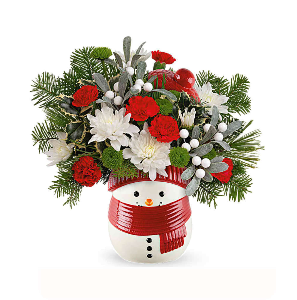 Frosty Wishes Bouquet - Whether it's filled with festive Christmas flowers or sweet treats, this cheerful frosty snowman treat jar vase brings whimsical winter cheer and joy to your loved one's face.   The Frosty Wishes Bouquet includes miniature red carnations, green button spray chrysanthemums, and white cushion spray chrysanthemums, accented with variegated holly, white pine, and noble fir. It is beautifully presented in the Frosty Wishes Treat Jar, adding festive charm to any occasion.