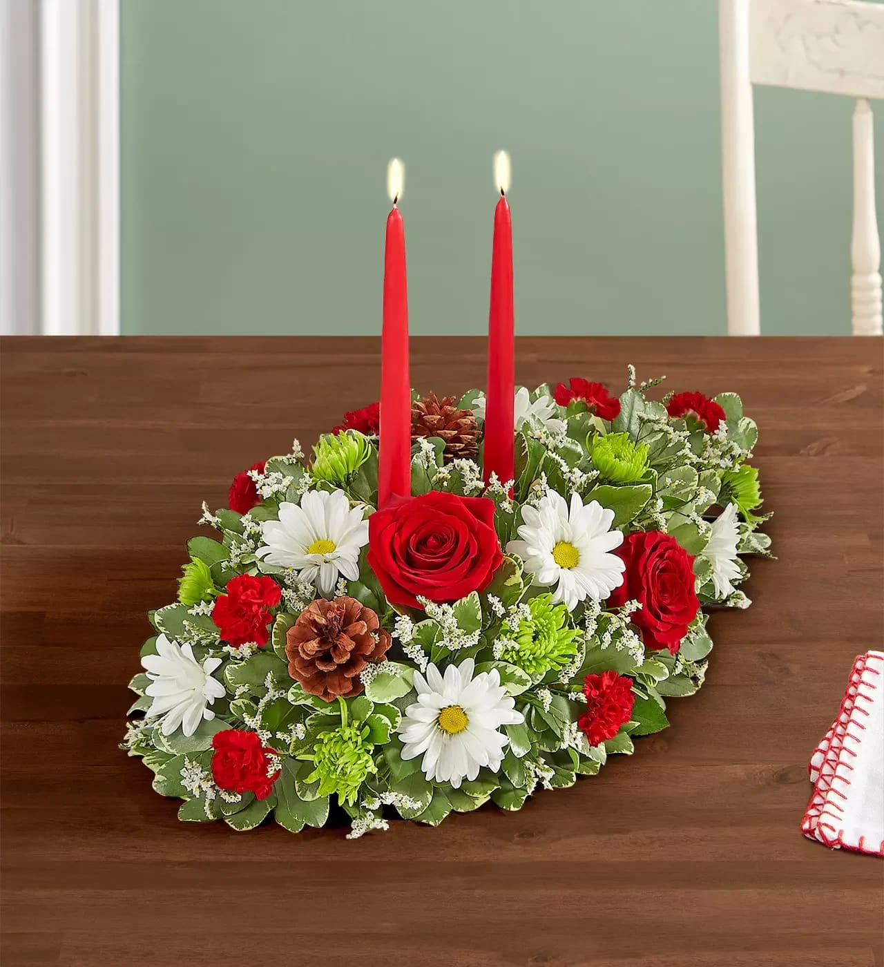 Seasons Greetings - Introduce the holiday season with timeless elegance. Our exquisite Christmas centerpiece features traditional holiday flowers and charming embellishments, exuding warmth and festive cheer. The addition of tapered candles adds an extra touch of sophistication, creating a perfect centerpiece for delighting loved ones.