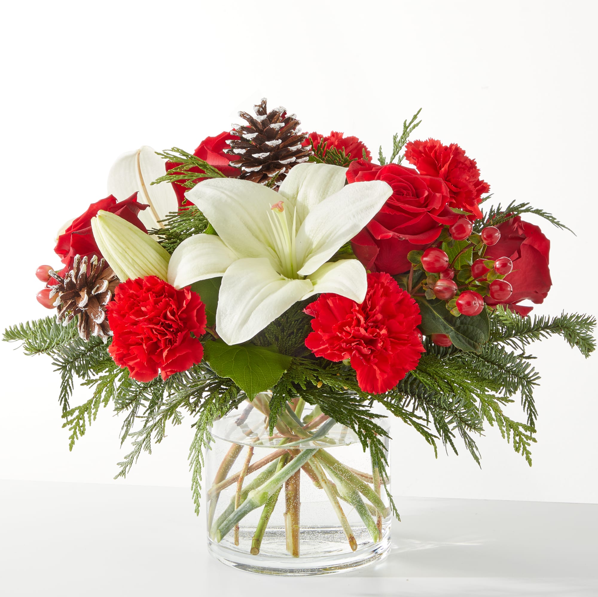 Oh So Jolly Bouquet On Sale - This bouquet is sure to shimmer as bright as the holiday lights with lush carnations, roses, and lilies bursting from the vase. approximately 10"H x 13"W.