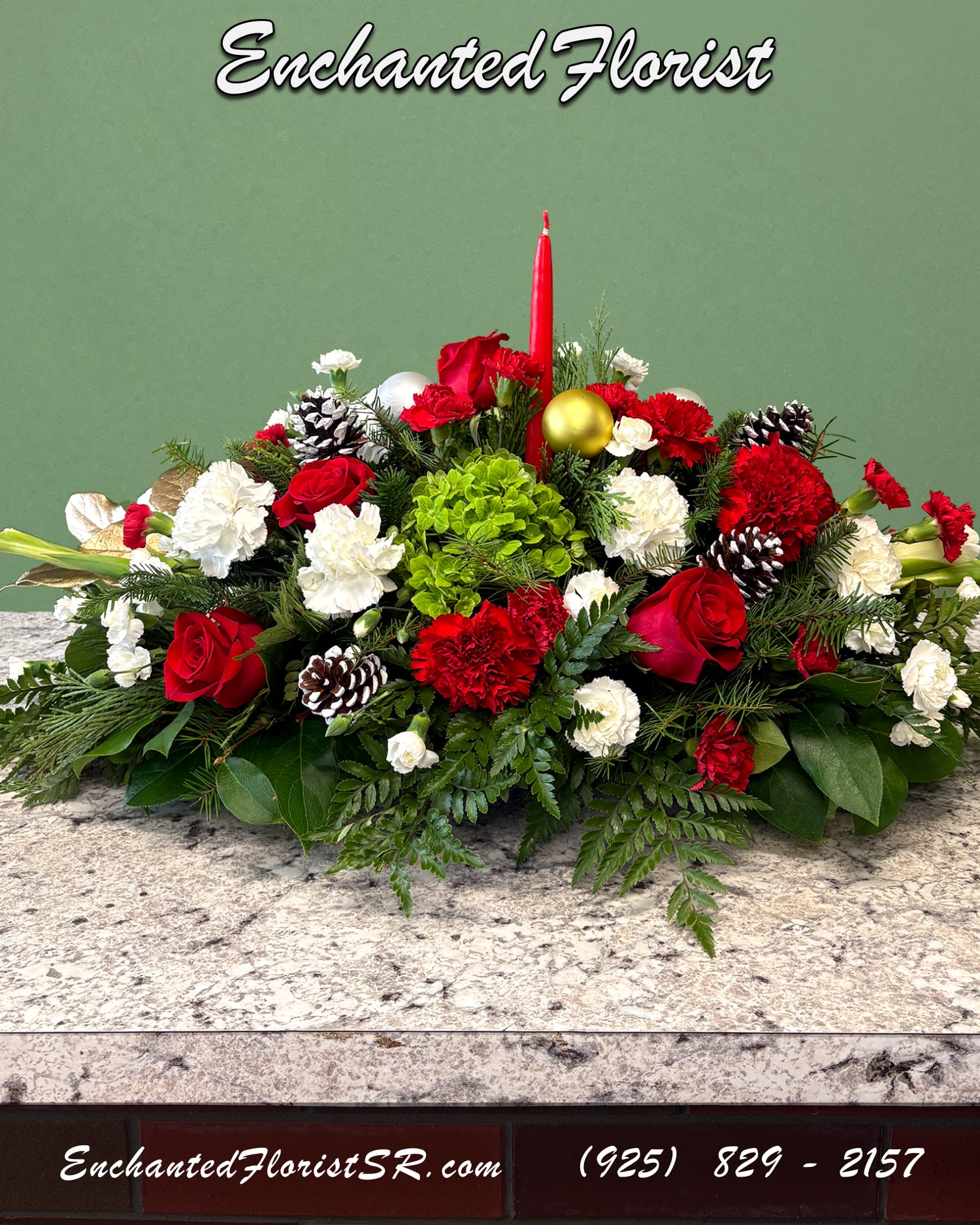 Holiday Glow - Long Holiday Centerpiece - A festive long holiday centerpiece designed to brighten any table. Showcasing a holiday palette and featuring flowers such as roses, carnations, mums, hydrangeas, and gladiola. Accented with freshly-cut greens such as leather fern and noble fir. Decorative snowy acorns added for texture and depth. A red tapered candle rises at the center, creating a soft, festive glow that is perfect for holiday gatherings.  Ideal for brightening the table and bringing a warm joyful glow to any space.  Orientation: All-Around  Arrives In: 12" centerpiece tray w/ tapered red candle  Approximate Dimensions: 14" Tall (including candle) 24" Wide 12" Depth