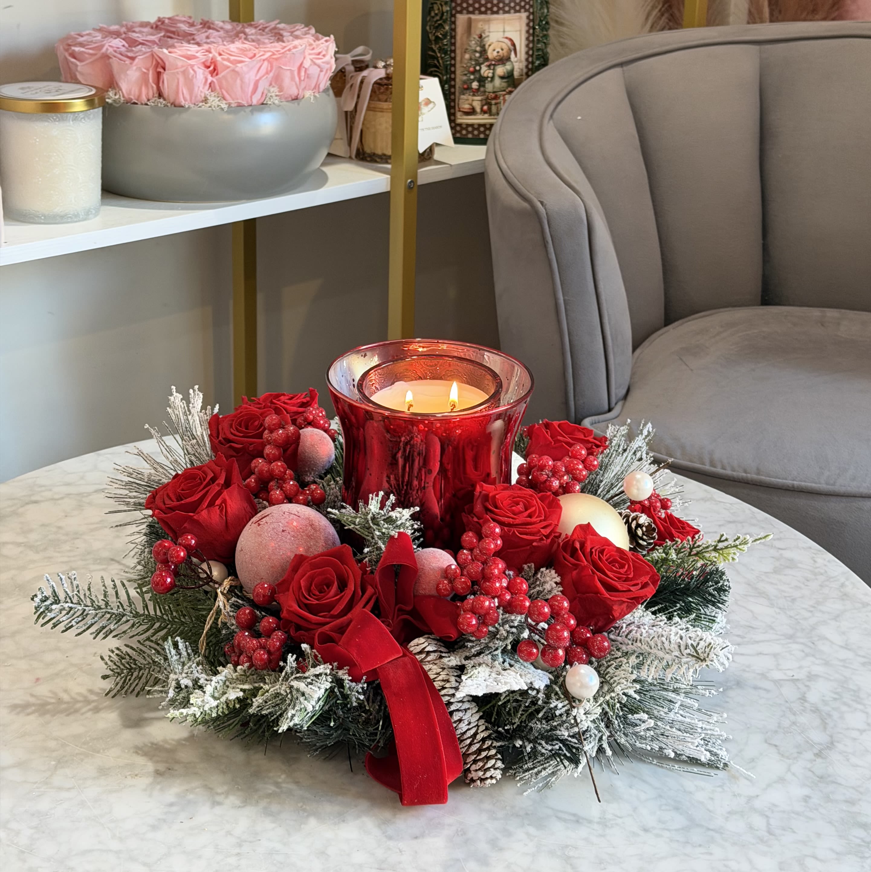Eternal Rose Holiday Candle Centerpiece - Eternal Rose Holiday Candle Centerpiece is a luxurious table arrangement crafted with real preserved (eternal) roses, designed to create warmth, elegance, and festive ambiance.  This centerpiece features vibrant eternal red roses arranged around an elegant candle holder, complemented by frosted winter greenery, seasonal accents, and decorative details. The preserved roses retain their beauty for months and even years without water or maintenance, making this piece both timeless and practical.  Perfect for dining tables, coffee tables, or mantels, it adds a refined holiday touch to any interior and becomes a stunning focal point during Christmas and winter celebrations.   Made with real preserved (eternal) roses  Designed as a table candle centerpiece  Long-lasting, maintenance-free décor  Perfect for Christmas &amp; winter season 