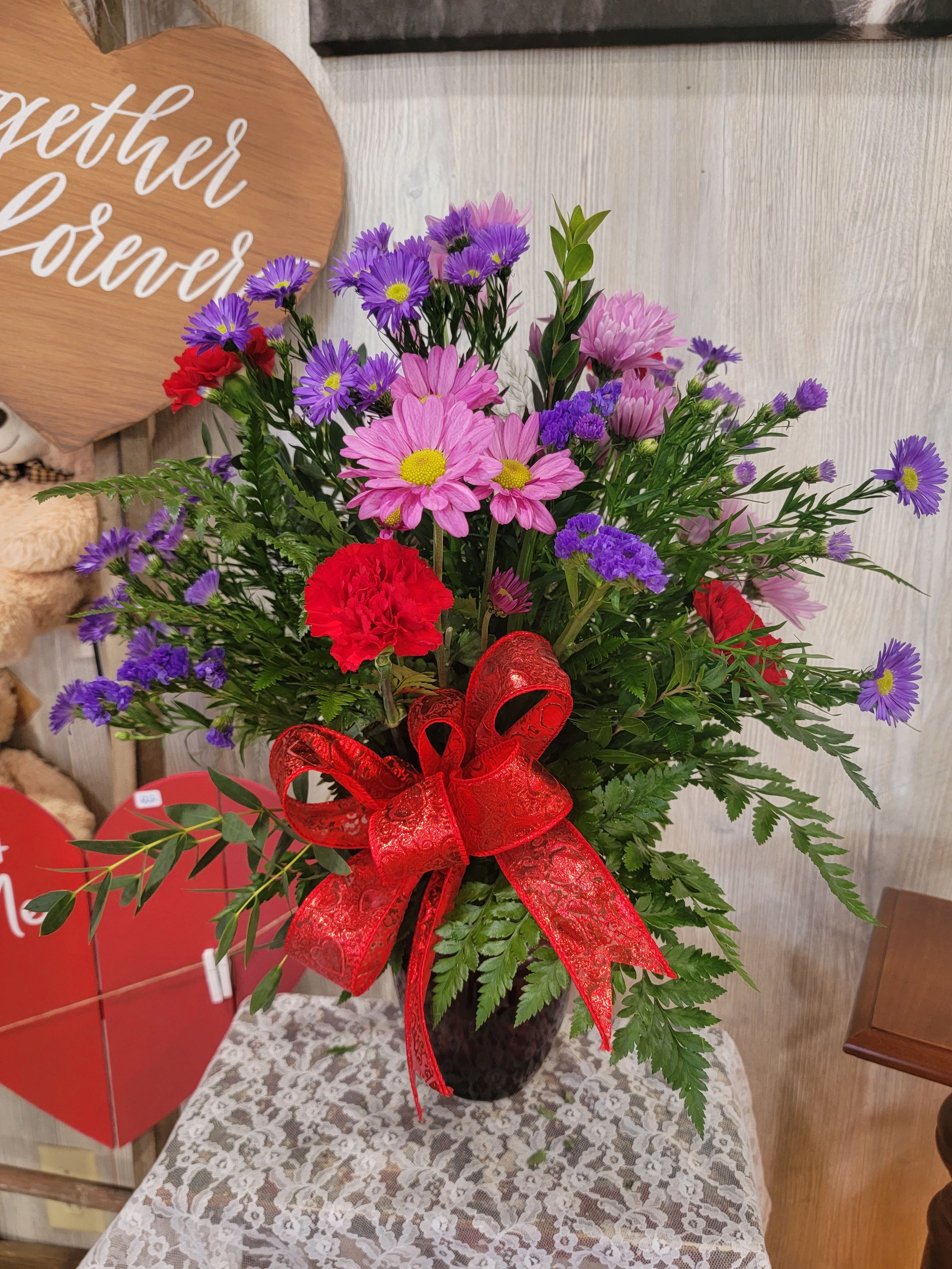 Blooms of Love  - A beautiful vase arrangement full of a mixture of blooms and greenery. Premium and deluxe pricing includes more flowers. 