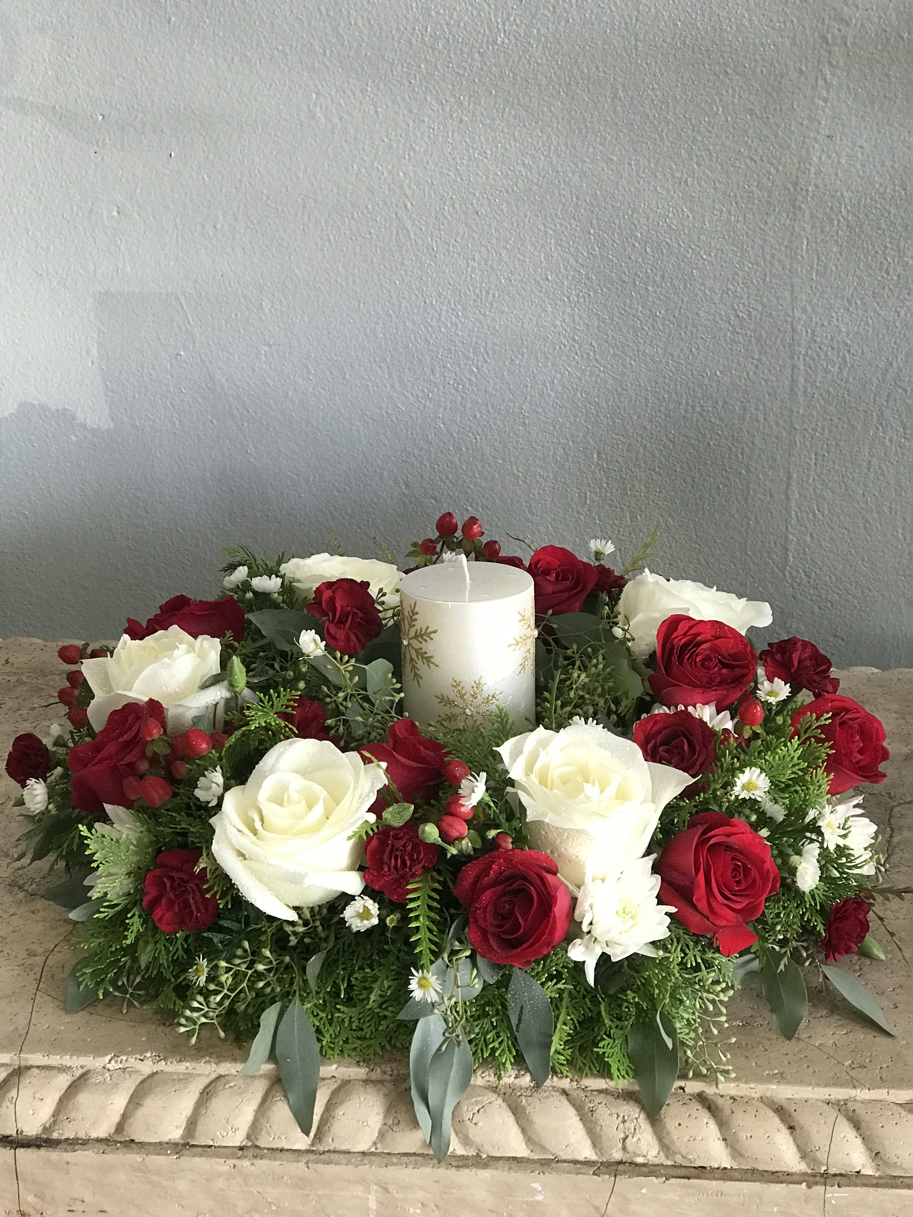 Red and Light Centerpiece  - A delightful centerpiece that brings all the home decor together for the Christmas season. With the table set for a healthy meal this red and white centerpiece with roses, carnations on a bed of textured Christmas greens brings warmth and comfort to any room. Candle not included. Available for pickup or delivery in Palm Beach, West Palm beach and surrounding areas. 
