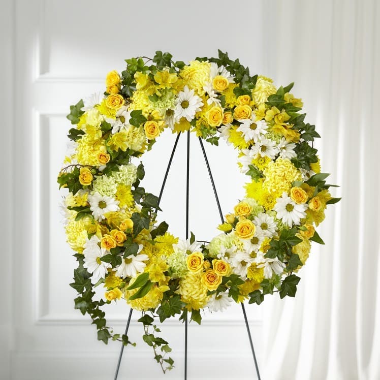 The Golden Remembrance Wreath - Whether yellow was their favorite color or it captures the essence of their radiance, a ring of bright blooms thoughtfully displays your sentiment.   Our Golden Remembrance Wreath is composed of spray roses, daisy pompons, carnations and more. Each flower is selected to beautifully accent one another and the love you are sending.   Approximately 24" in diameter.