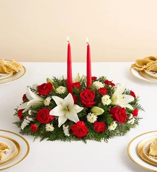 Traditional Christmas Centerpiece - Our classic table arrangement is an idyllic centerpiece for your Christmas celebration. Beautifully designed with long-lasting blooms in seasonal colors, this fragrant gathering features red taper candles to cast a warm, inviting glow throughout the holidays. 