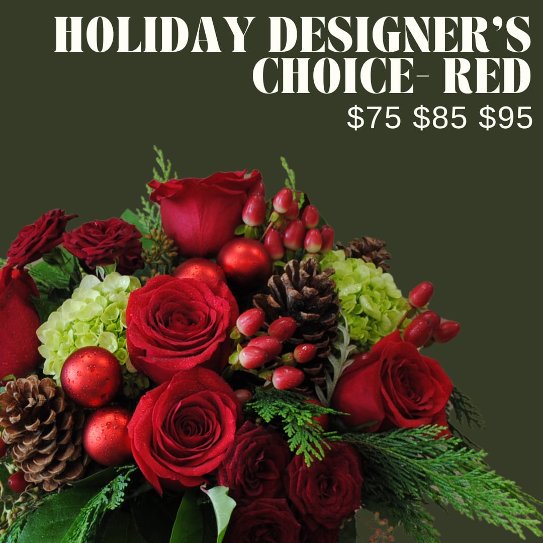 Holiday Designer's Choice Red Arrangement - A low and lush bouquet artfully designed in a vase or basket using red toned florals, and winter accents and greens!!  *Image shown is valued at $95 *The $75 and $85 price points will be made with fewer flowers to match the value using blooms in the same color palette