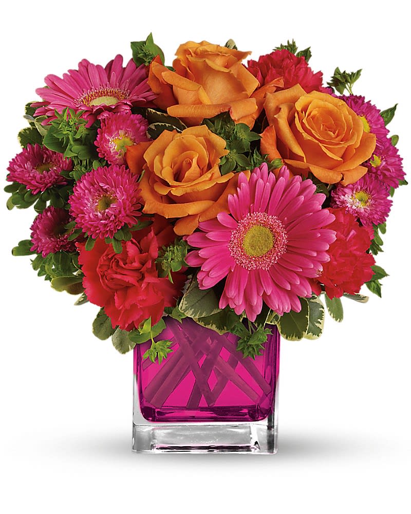 Turn Up The Pink Bouquet - Turn up the heat with this hot pink, haute couture creation! Super chic and oh-so-fun in its fuchsia Cube vase, this girly mix of gerberas and roses is sure to warm her heart. This brilliant bouquet of lush orange roses, hot pink gerberas, carnations and matsumoto asters are accented with bupleurum and variegated pittosporum. Delivered in a 4x4" glass cube - arrangement measures approx. 11.5x11" for Standard size, 12.5x12" for Deluxe, and 13x13.5" for Premium.