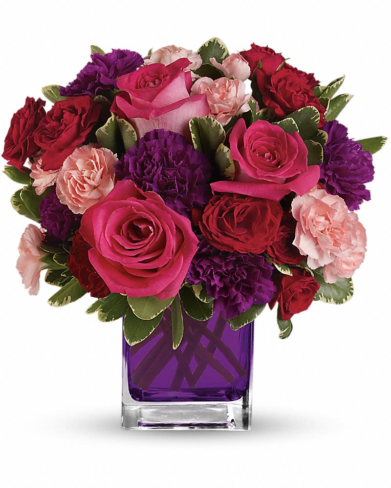 Bejeweled Beauty - Pure romance. Hot pink roses and dark red spray roses are brightly arranged inside our violet cube. Hot pink roses, dark red spray roses, purple carnations and pink miniature carnations are accented with assorted greens. Delivered in Teleflora's glass 4x4" violet cube - arrangement measures approx. 11.5x11" for Standard size, 12.5x12" for Deluxe, and 13x13.5" for Premium.