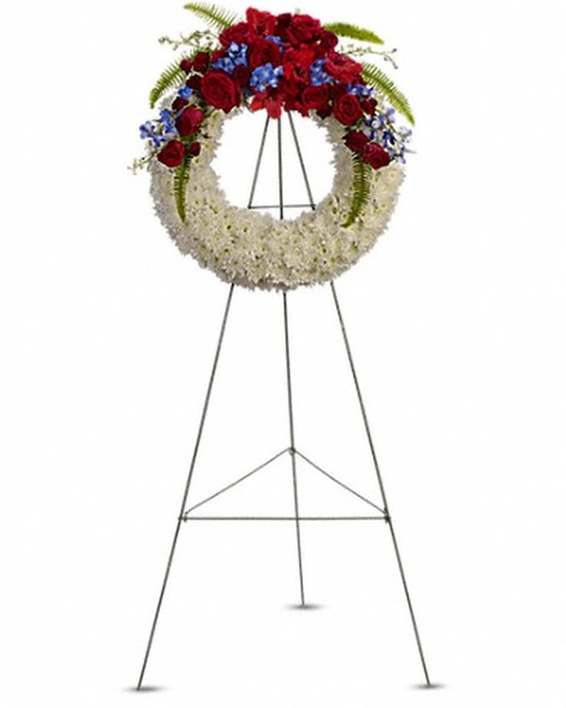 Reflections of Glory Wreath - A stunning display of patriotism, strength and sympathy. This red, white and blue wreath delivers a lovely message about the dignity of the deceased. A lovely array of flowers such as blue hydrangea, red roses and spray roses, delicate blue delphinium, red gladioli, white cushion spray chrysanthemums and more create a circle of serene beauty. Orientation: One-Sided All prices in USD ($)