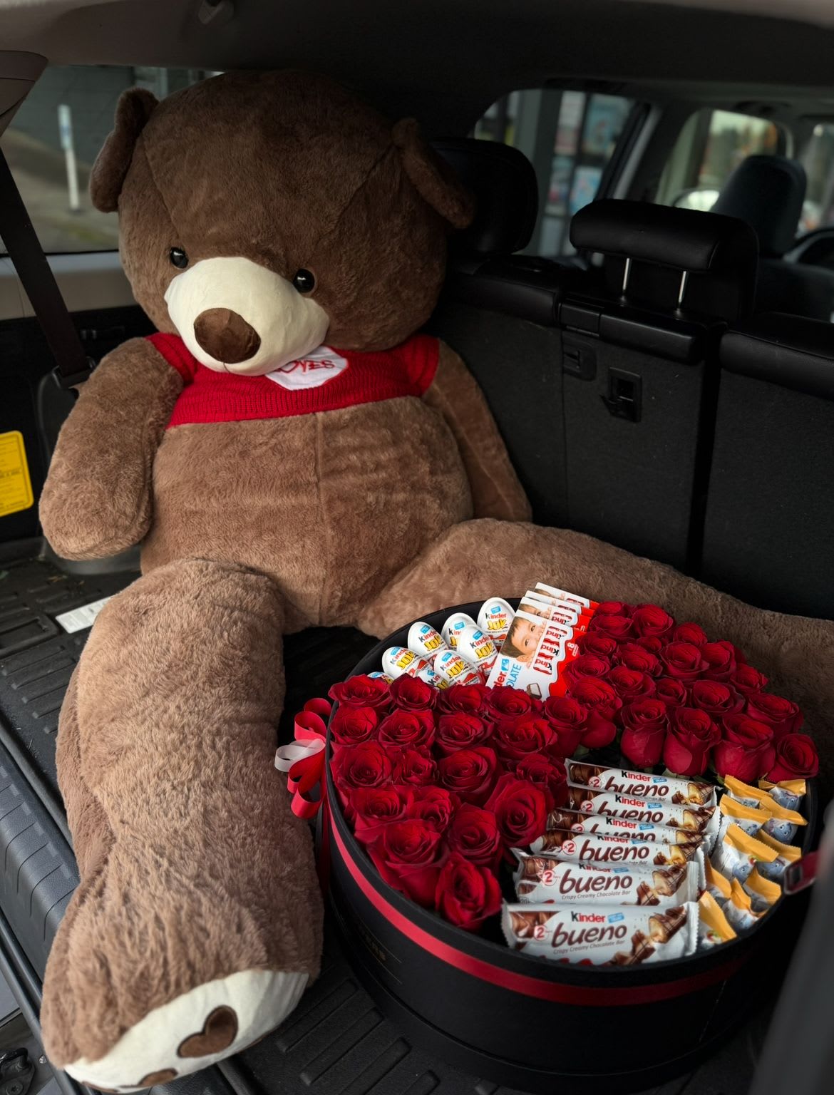 The Ultimate Gift of Love - A large, luxurious teddy bear holding a beautifully designed box filled with fresh flowers and an assortment of fine chocolates. This charming and indulgent gift combines softness, sweetness, and romance in one unforgettable surprise.  Perfect for birthdays, anniversaries, Valentine’s Day, or any moment when you want to express love in the most heartwarming way.