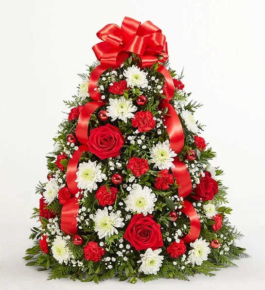 Holikday Flower Tree - Our flower tree arrangement is popular for its festive style and compact size, which fits perfectly into any space. Hand-designed with fragrant evergreens, then trimmed with decorative ornaments and a merry red bow on top, this floral twist on a traditional tree makes a truly magical gift for family, friends, or your own home.